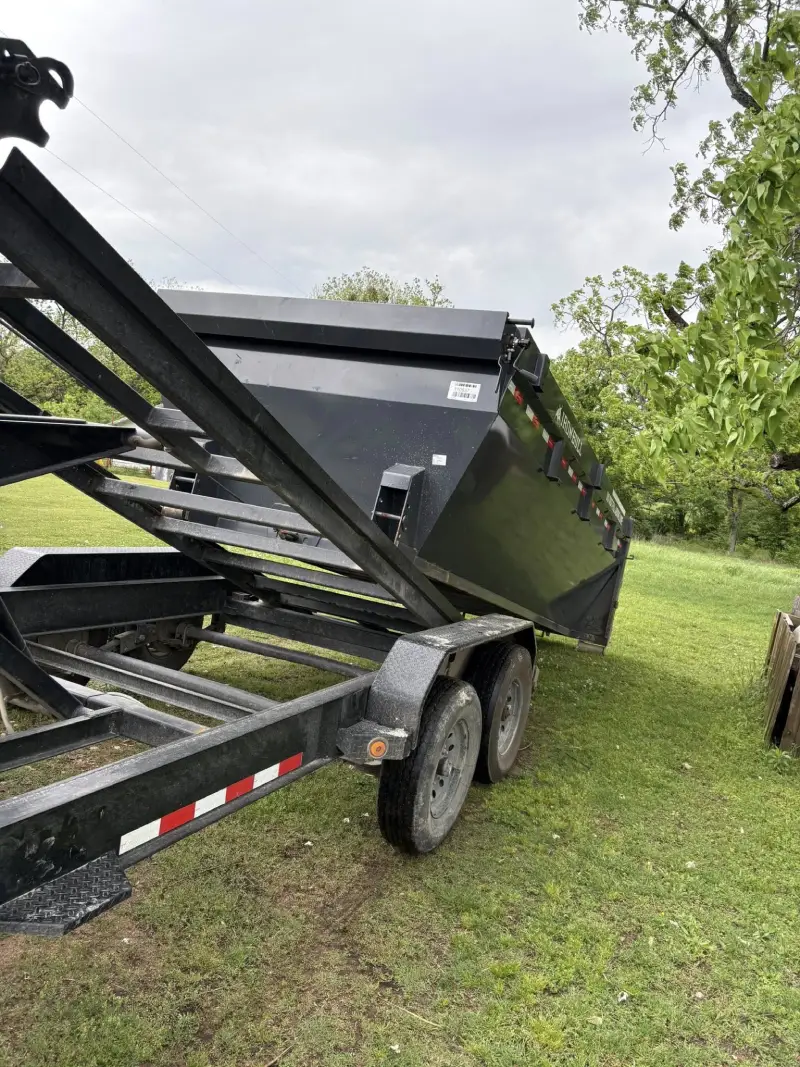 Ironbull roll-off dumpster trailer being unloaded in a yard