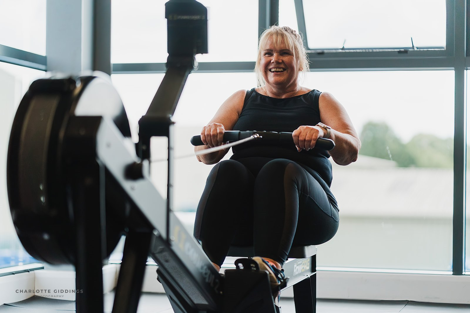 Member smiling on rowing machine at MEE-FIT