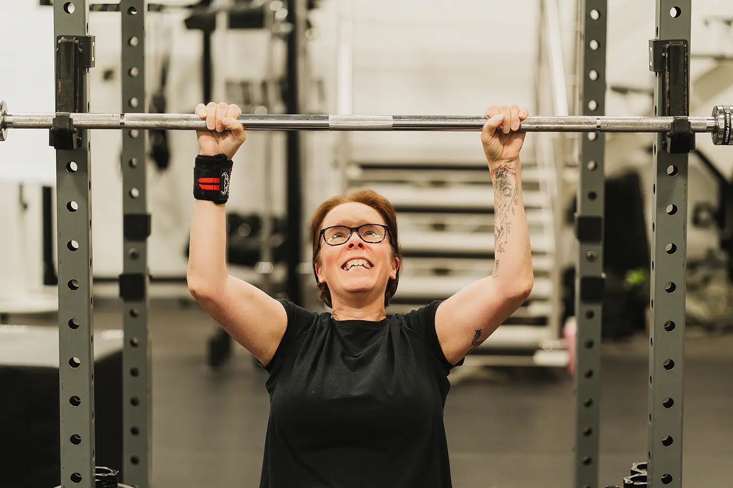 Member performing overhead press at MEE-FIT