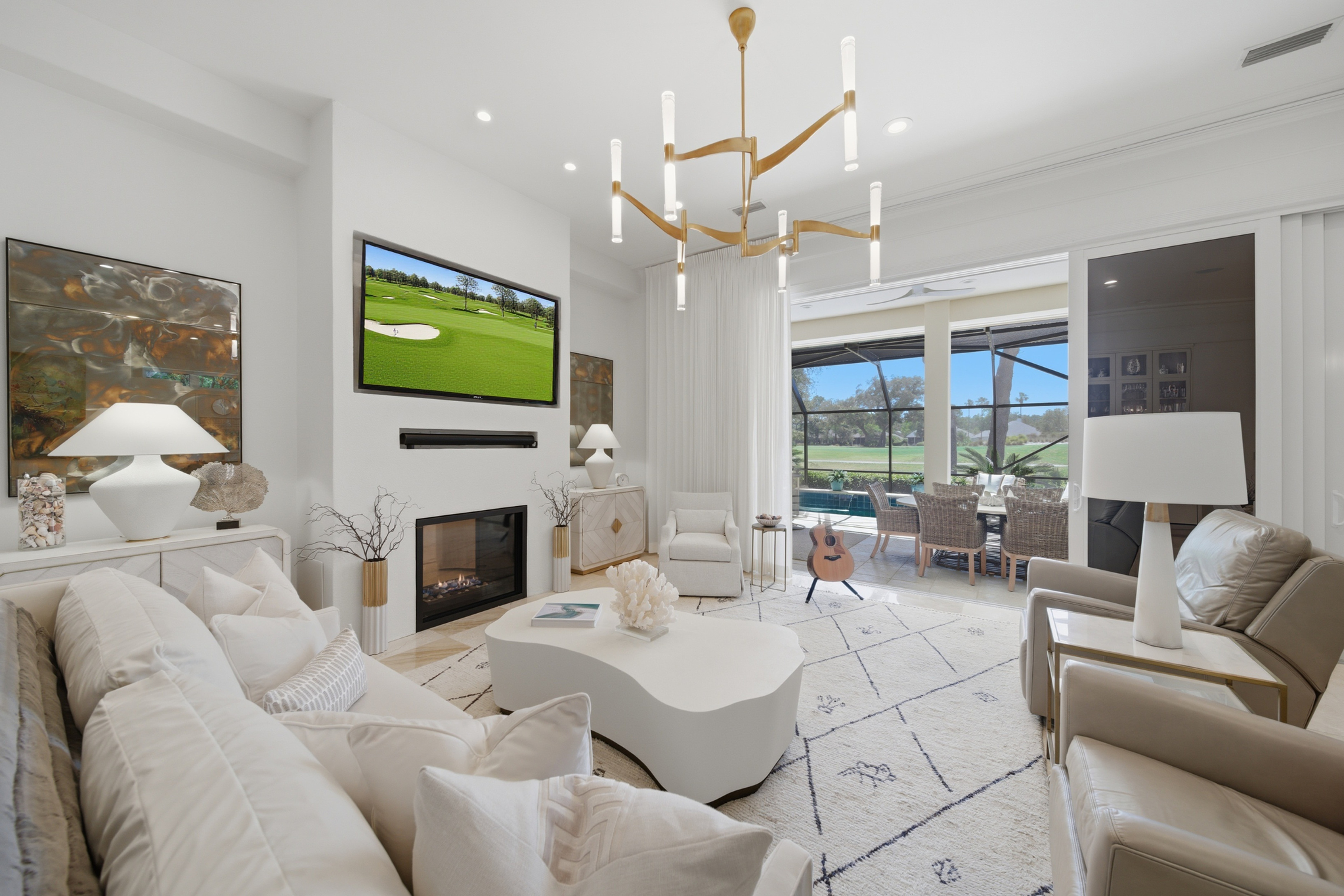 Great room interior with stone fireplace and golf course view