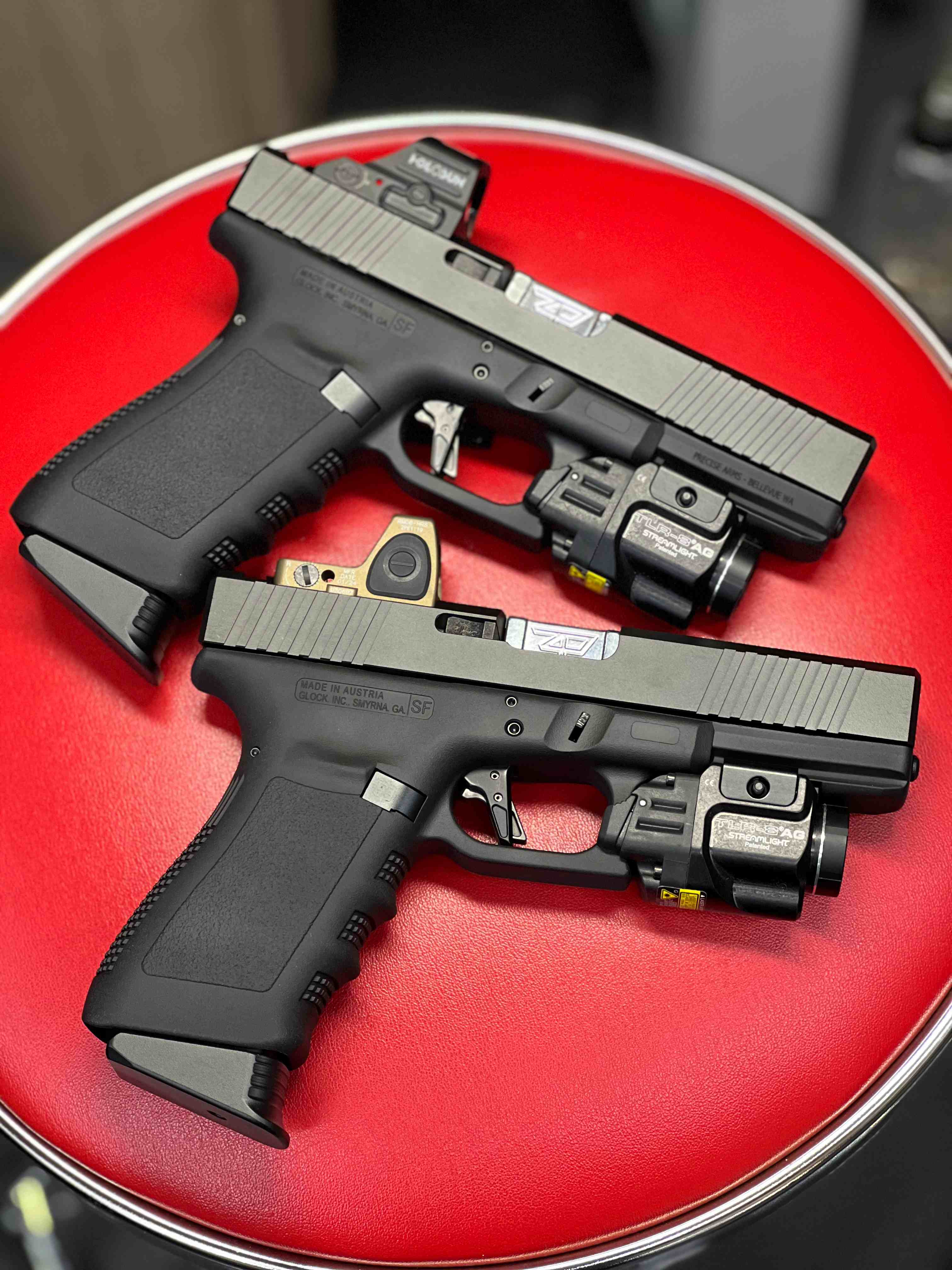 Pair of custom Precise Arms pistols with optics and mounted lights.