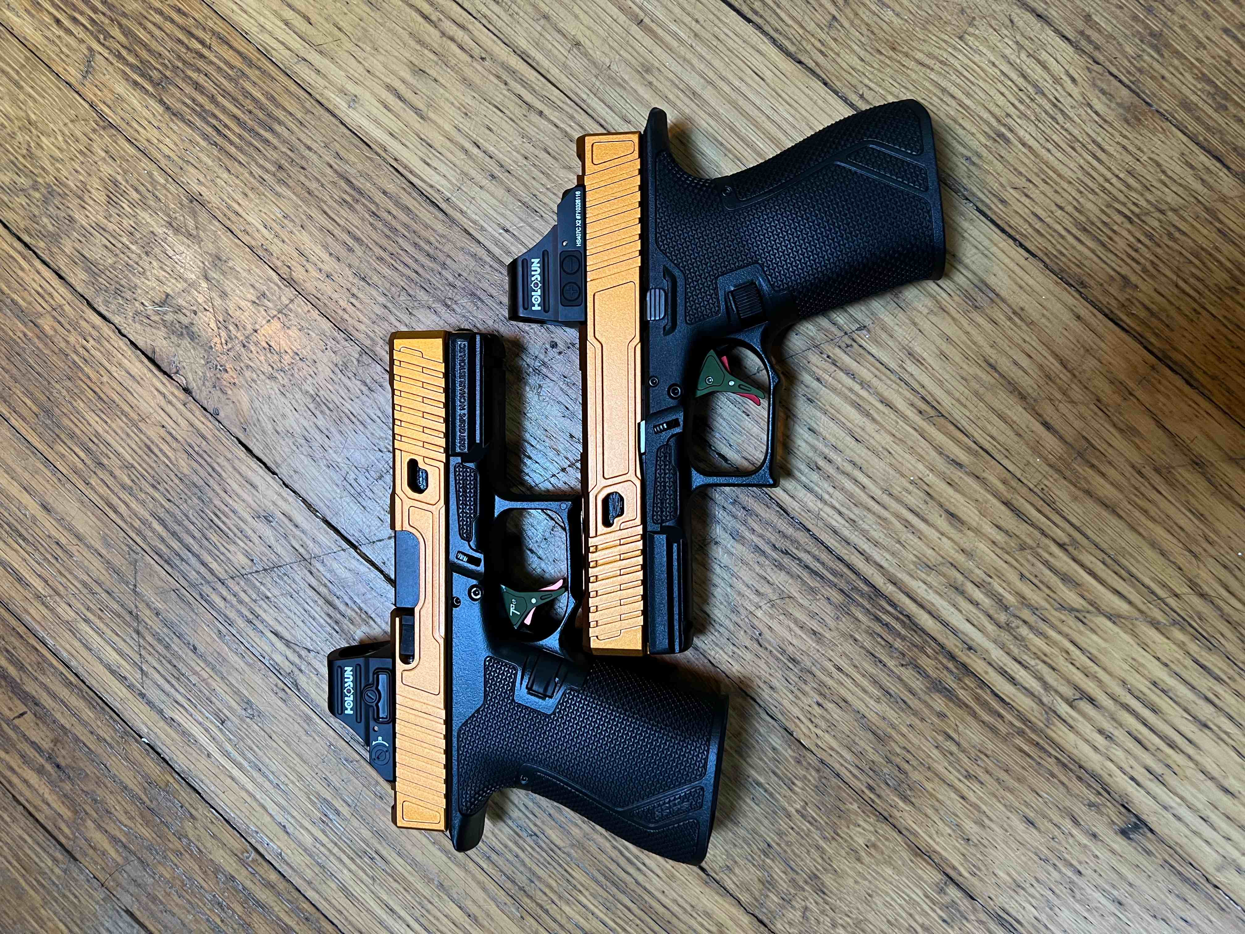 Custom Precise Arms pistol with optic and mounted light on a dark wood surface.