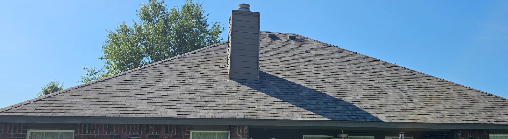 Close up of a new roof with chimney on a brick home in Broken Arrow, OK