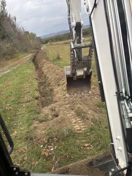 Mini excavator digging a long trench