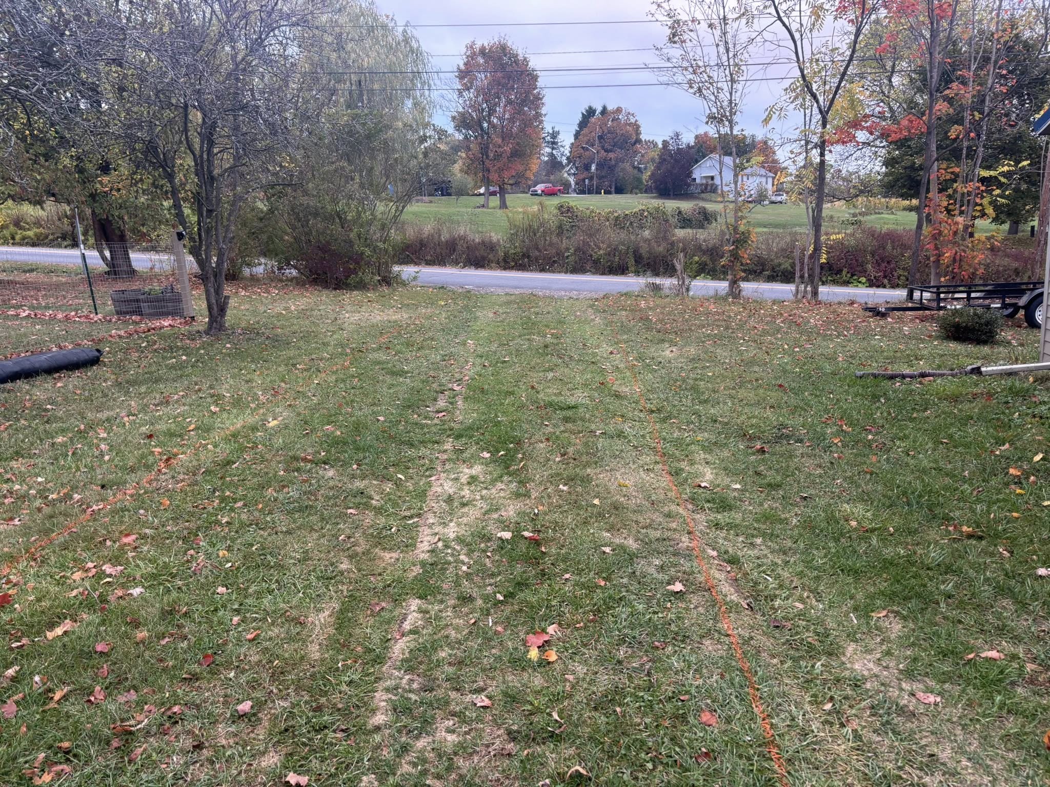 Orange marking paint on grass for driveway extension