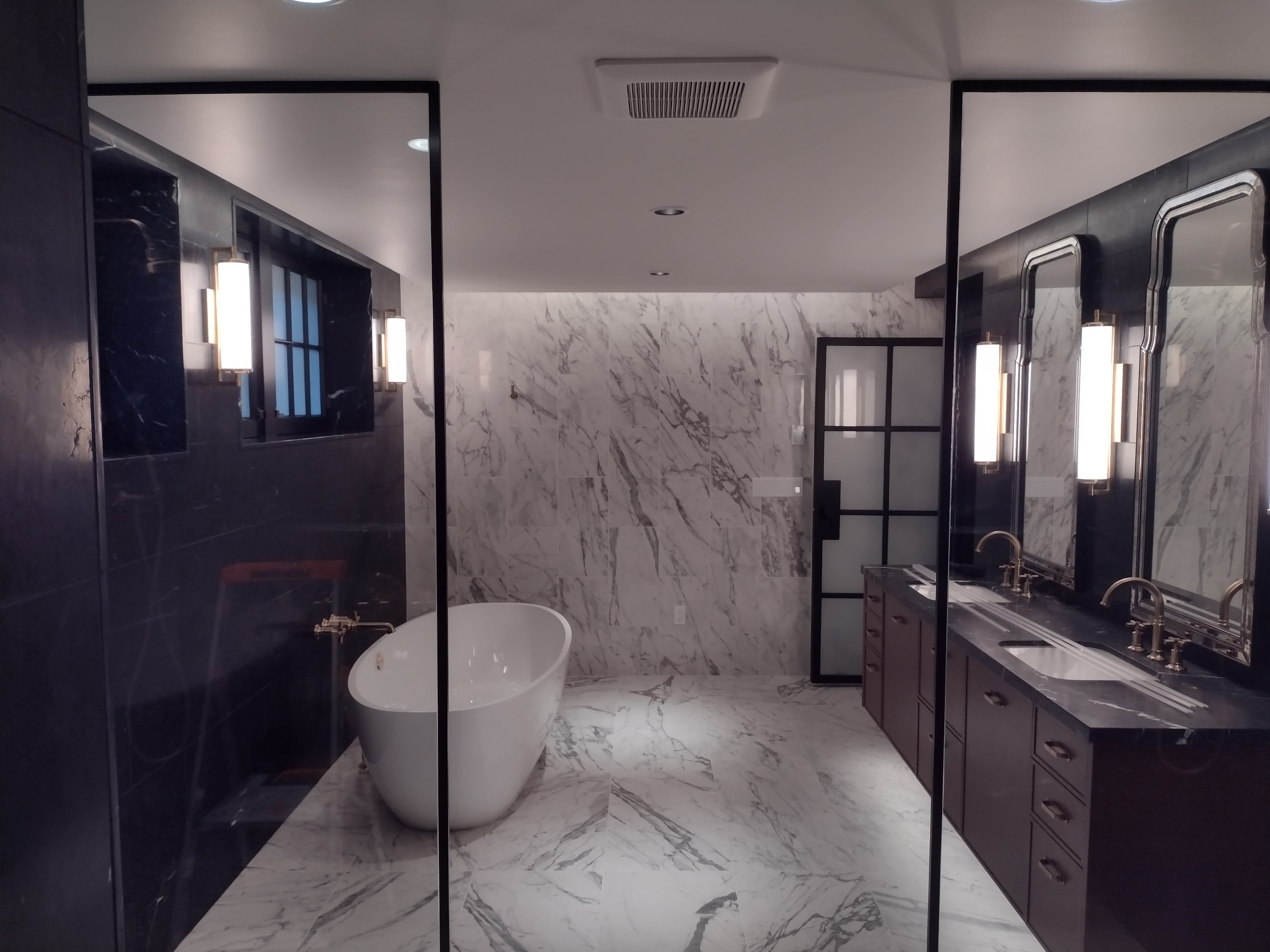 Luxurious master bathroom with custom vanity and wall sconces