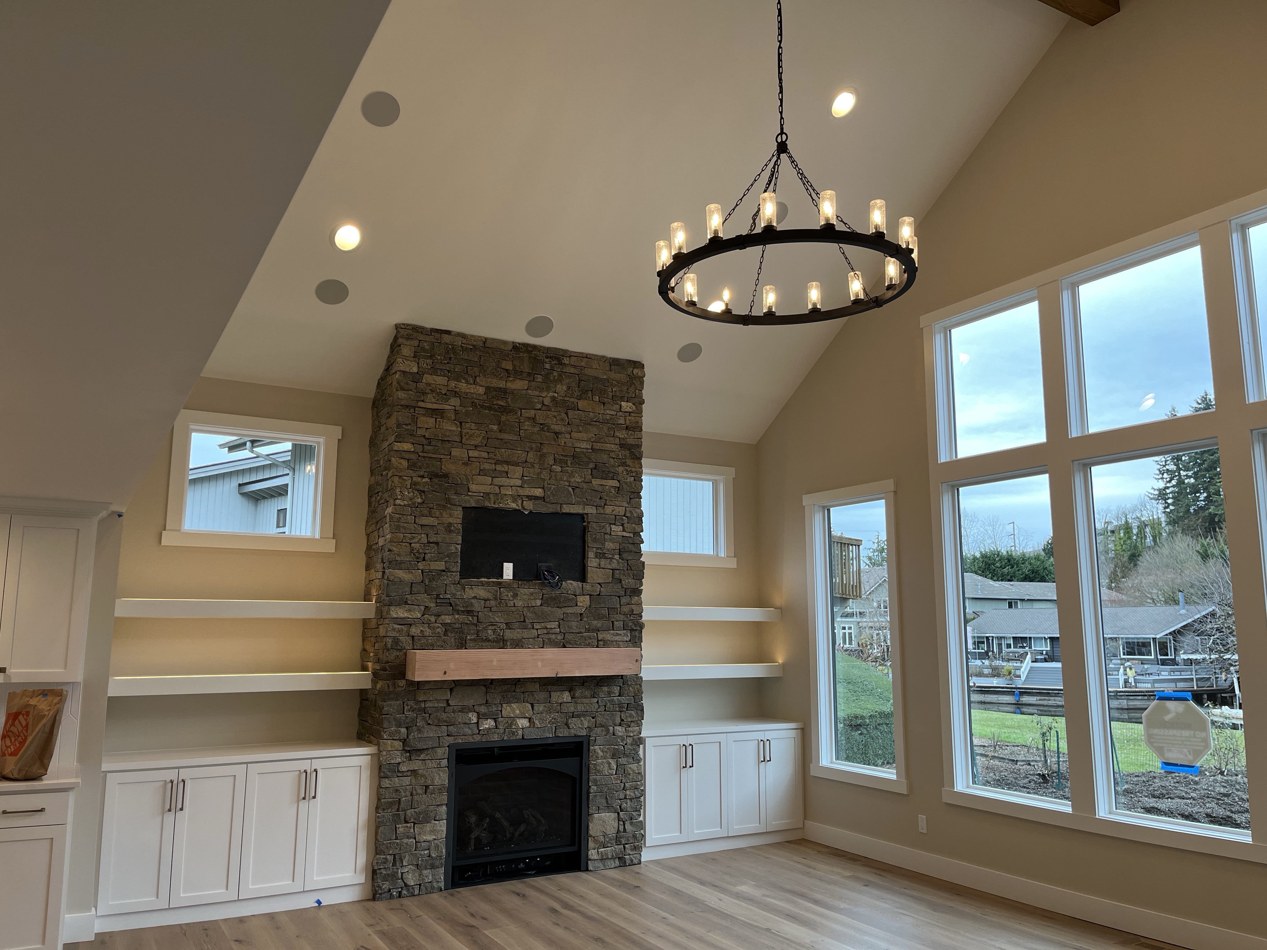 Living room with stone fireplace and chandelier