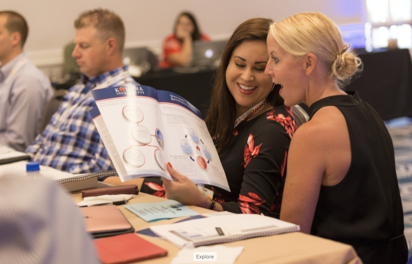 Attendees collaborating and engaging closely over event workbook and strategy materials