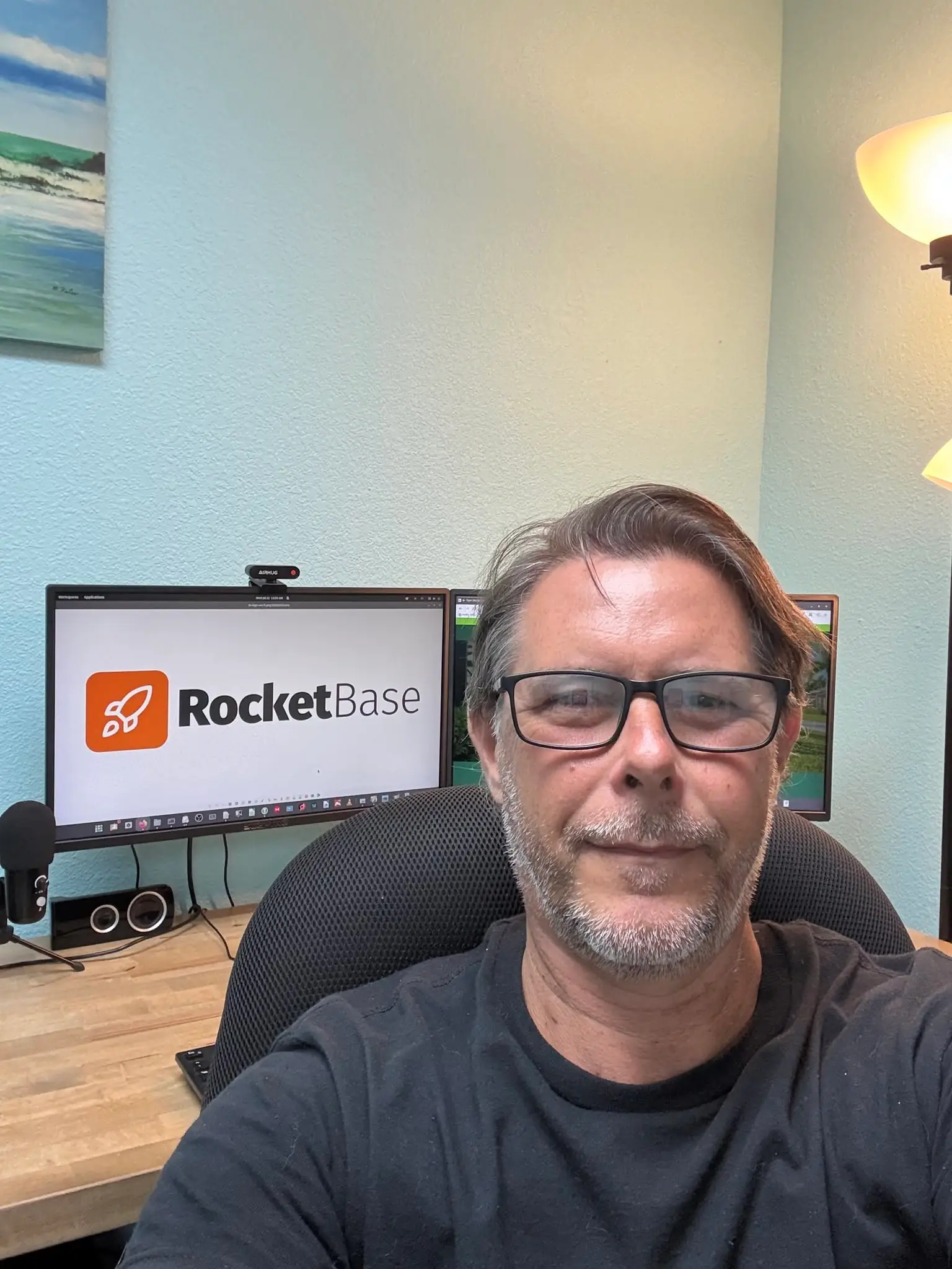 RocketBase founder Lowe in workspace with website design monitors