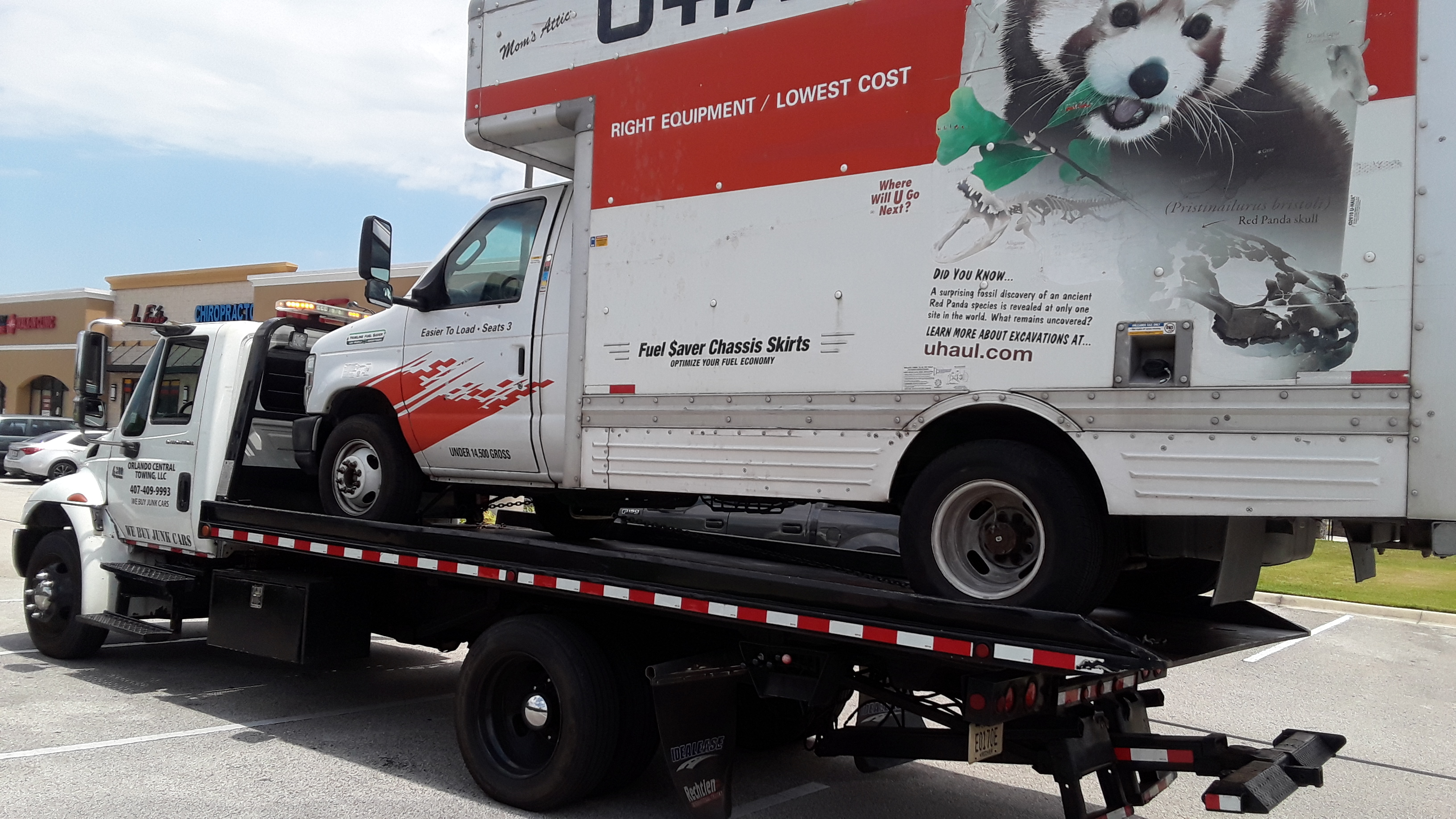 Orlando Central Towing flatbed tow truck hauling a U-Haul box truck in Central Florida