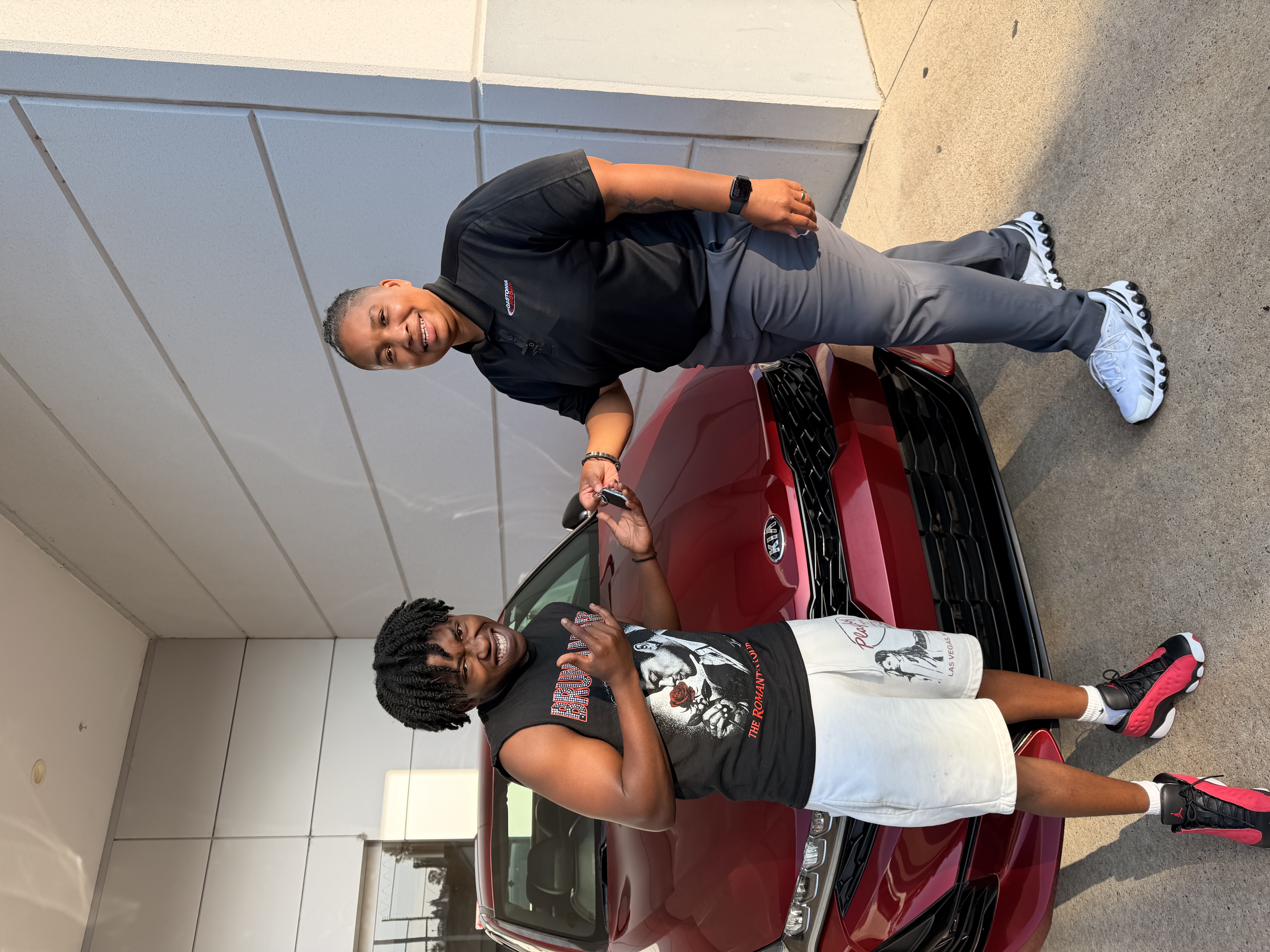 Dani handing keys to a happy customer with their new vehicle