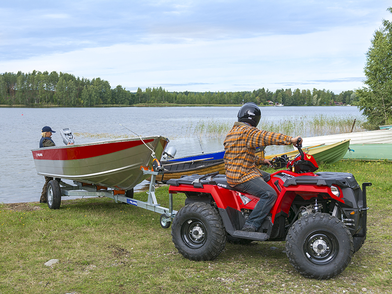 Polaris mönkijä vetää venettä järvelle