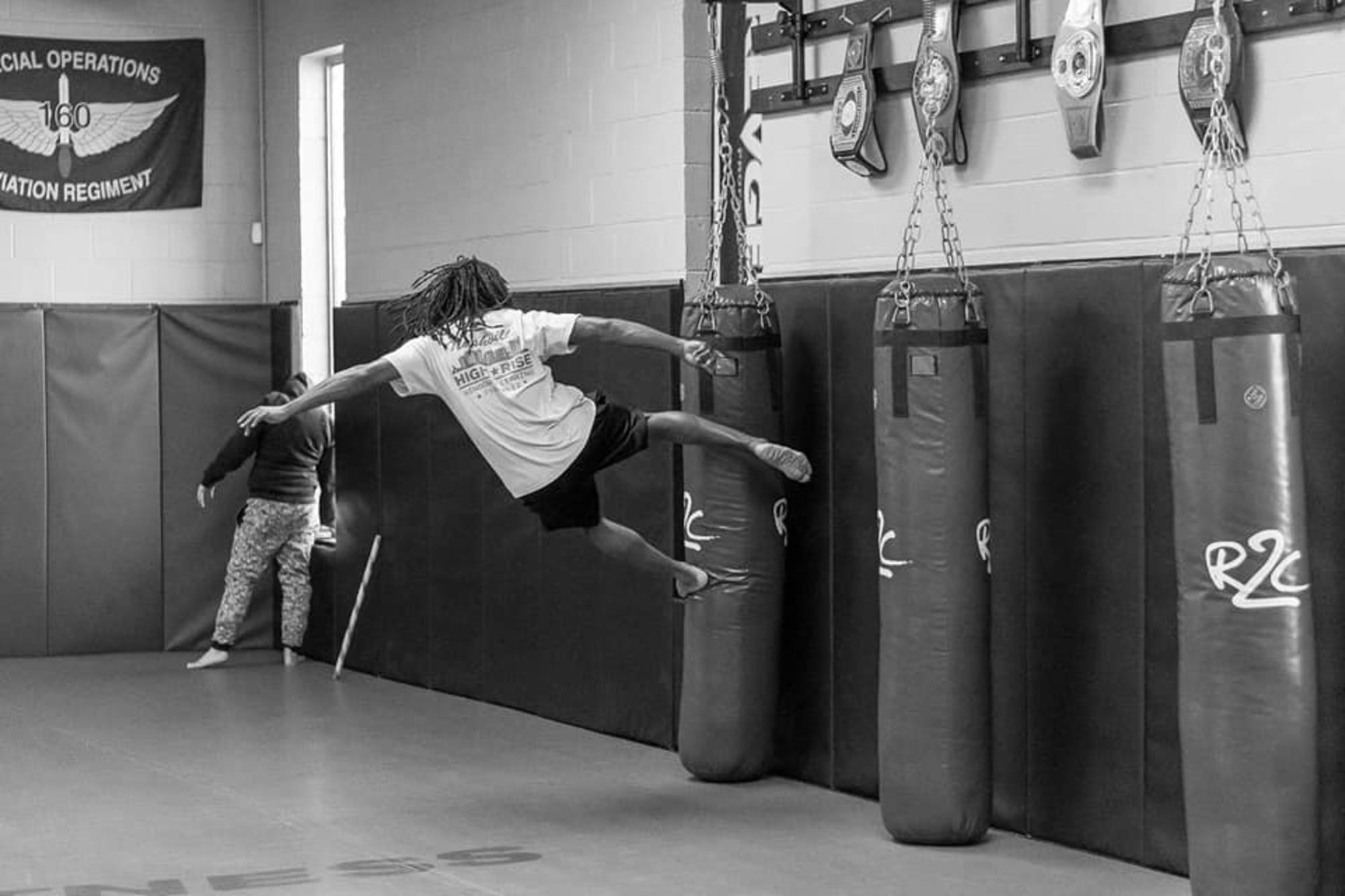 Muay Thai Clarksville TN Wildside — student performing a flying kick on a heavy bag