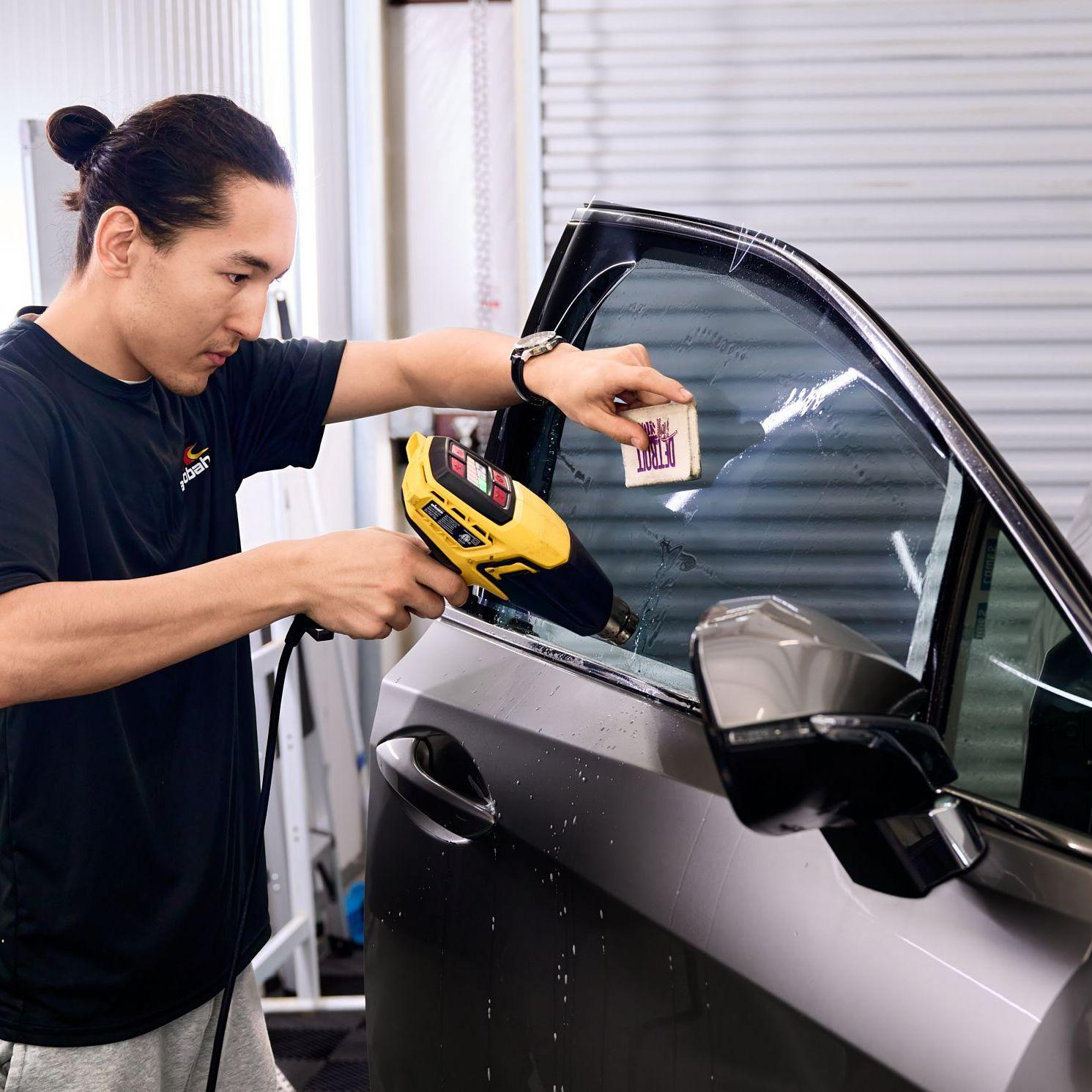 Professional window tint installation on a vehicle