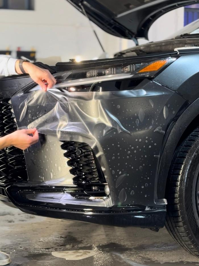 Paint protection film being applied to a vehicle hood