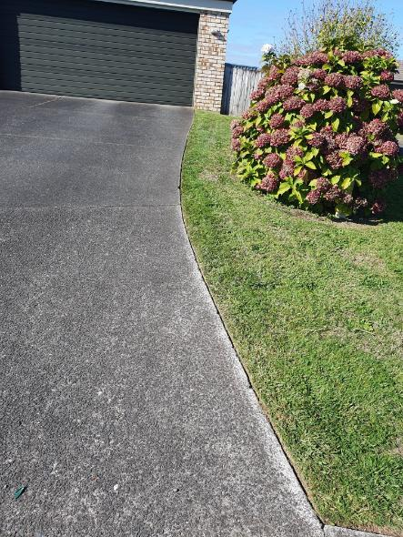 Clean driveway edge beside tidy lawn