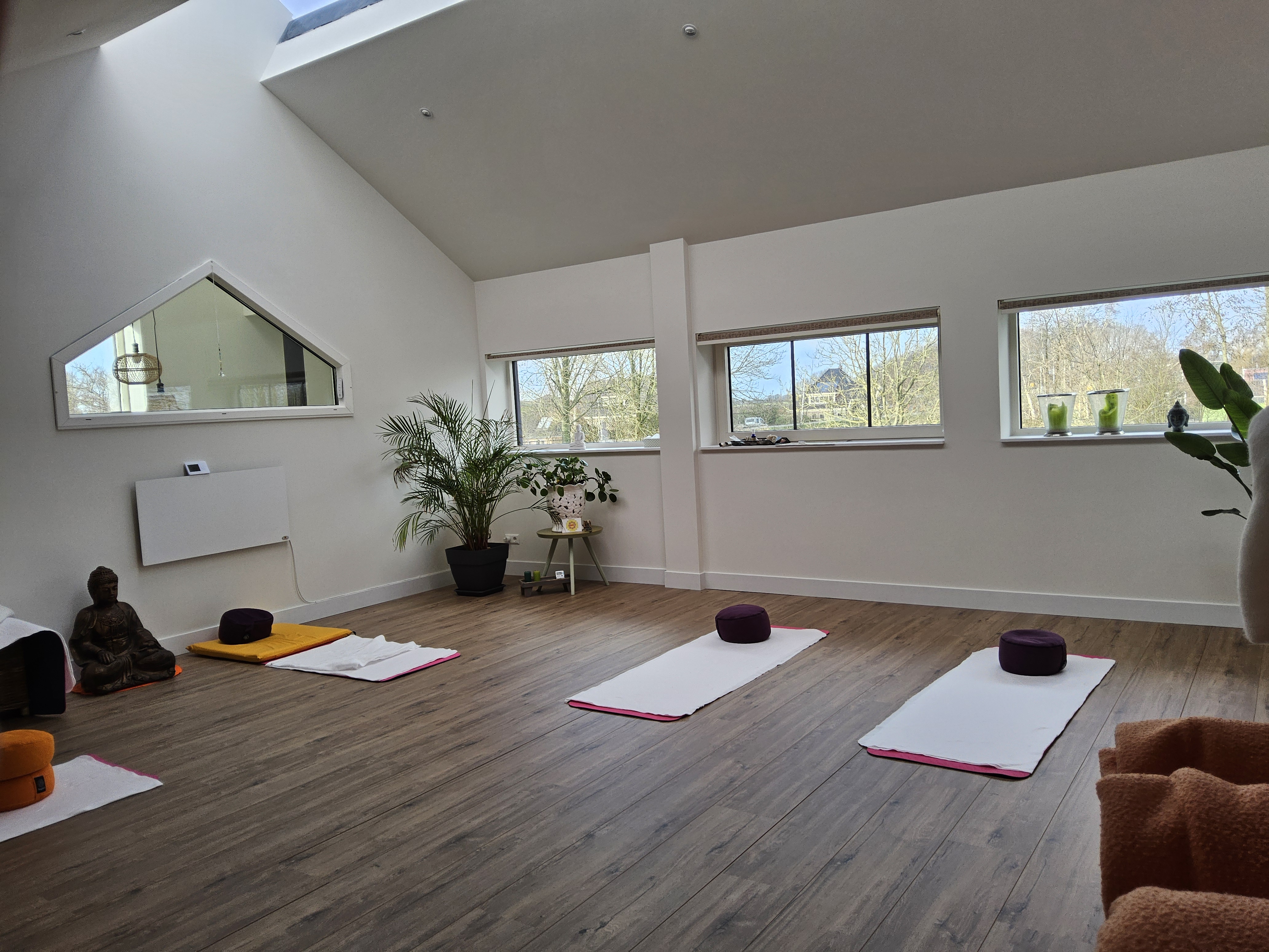 Sfeervolle yogaruimte met matten en Boeddhabeeld