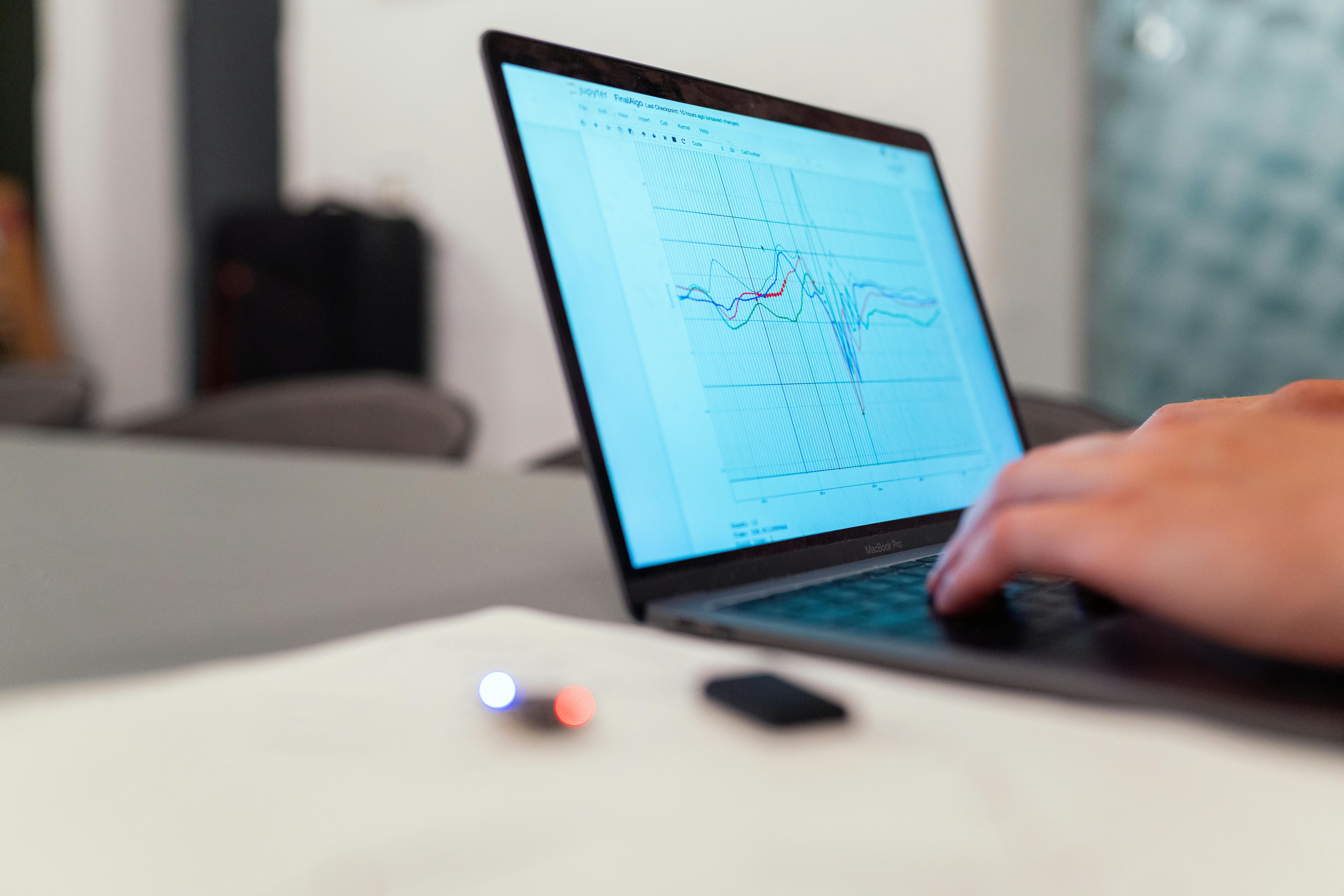 Person typing on a laptop showing a graph