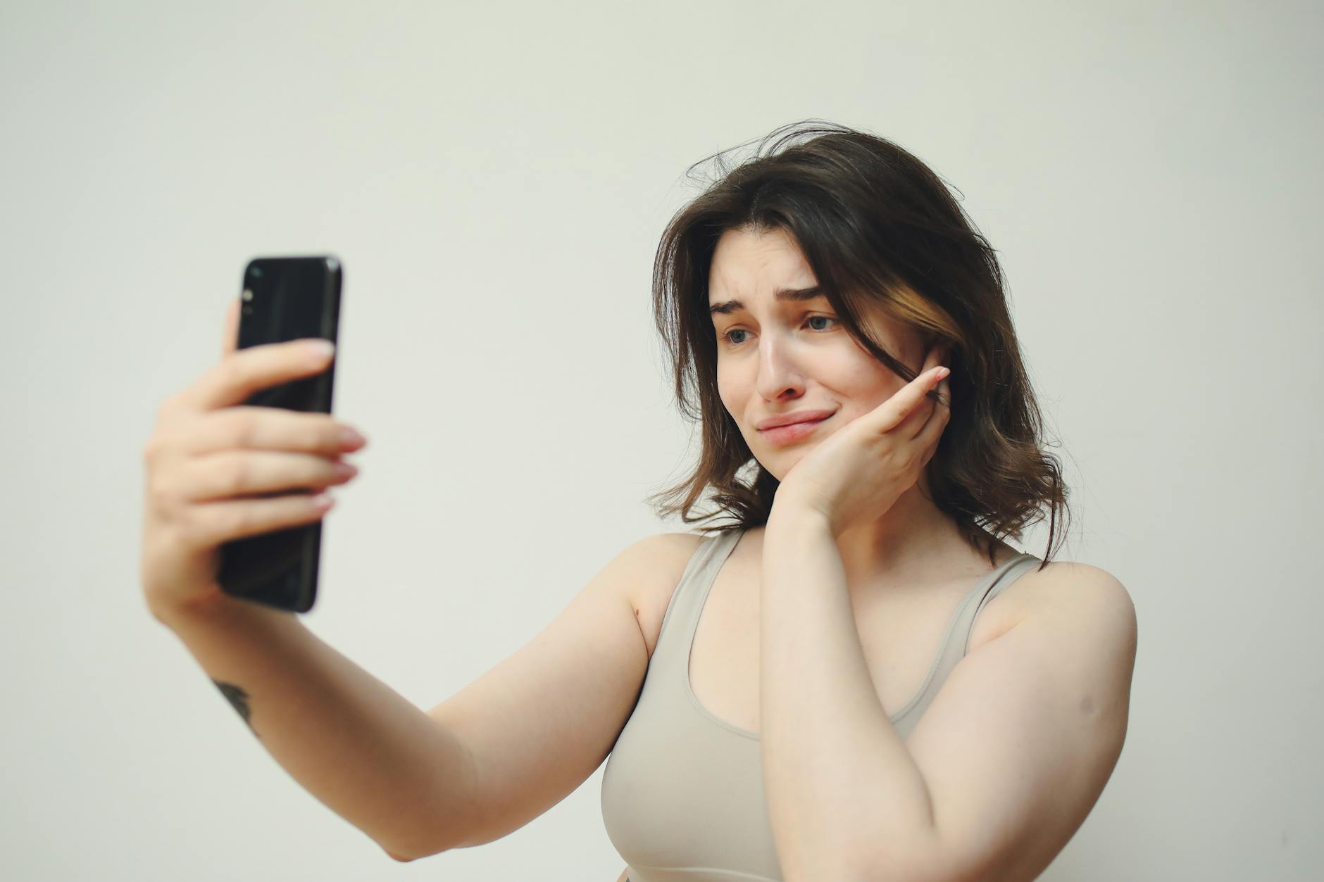 Woman taking a hesitant selfie