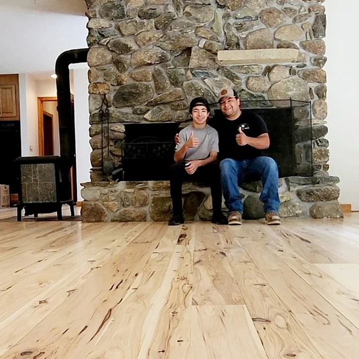 Cruz and his son on a newly finished hardwood floor