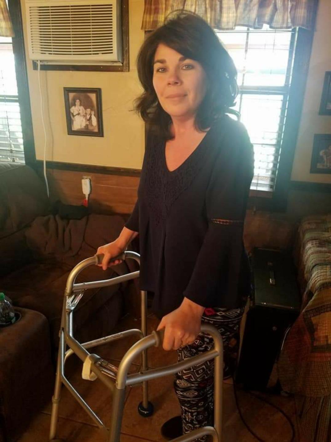 Woman using a walker in a cozy living room, reflecting the challenges of chronic illness and the journey towards recovery and support.