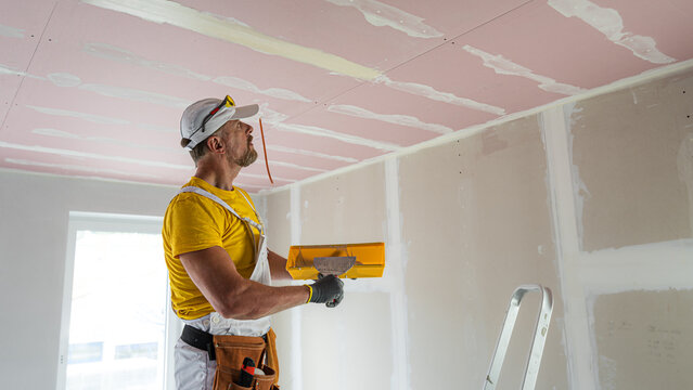 Professional taping and plastering on a ceiling