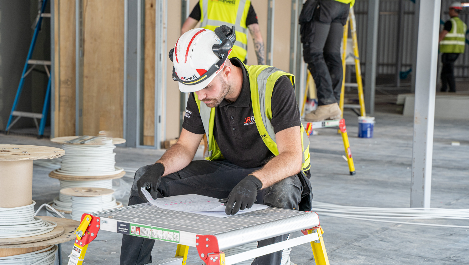 Engineer reviewing electrical drawings on site