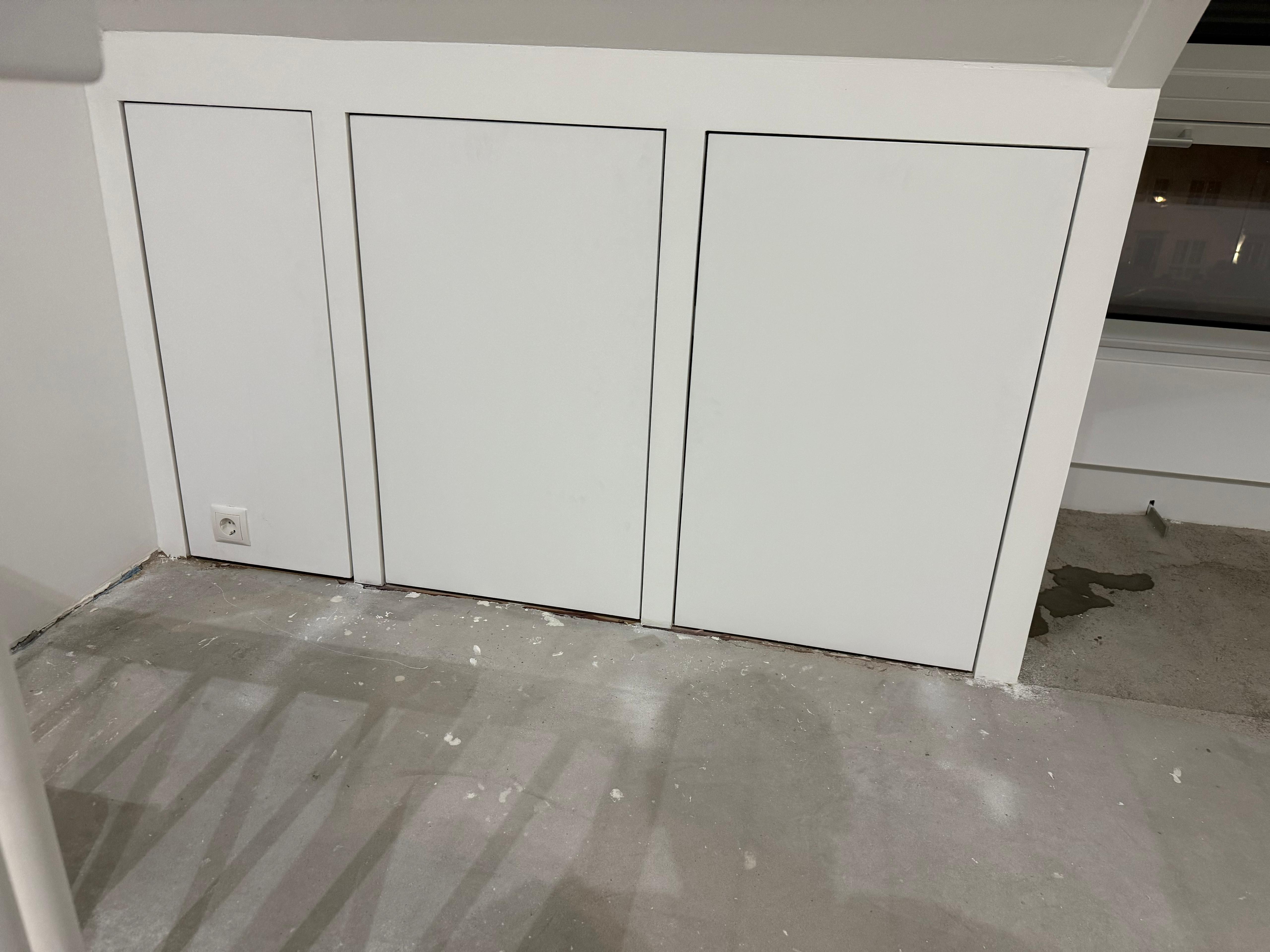 Witte inbouwkasten onder schuin dak timmerwerk Den Haag