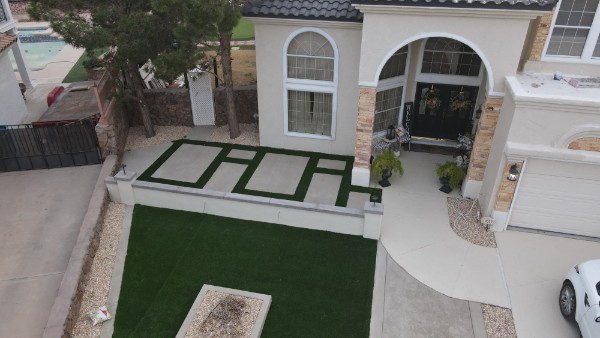 Turf installation with geometric concrete paver pattern — aerial view