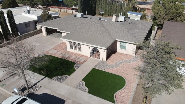 Aerial view of residential property with dual turf areas and rock landscaping