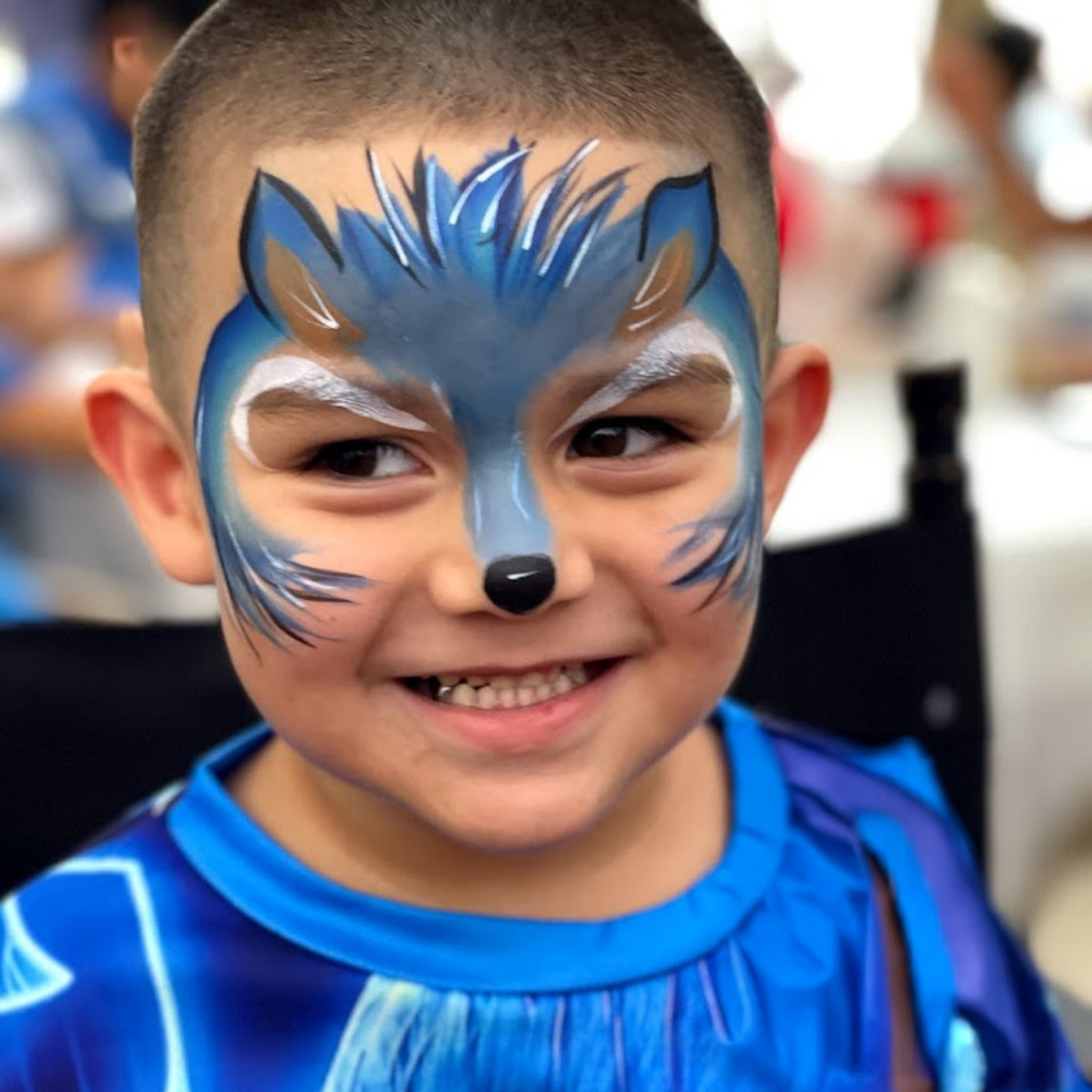 Professional face painter creating a butterfly design for a child in Houston