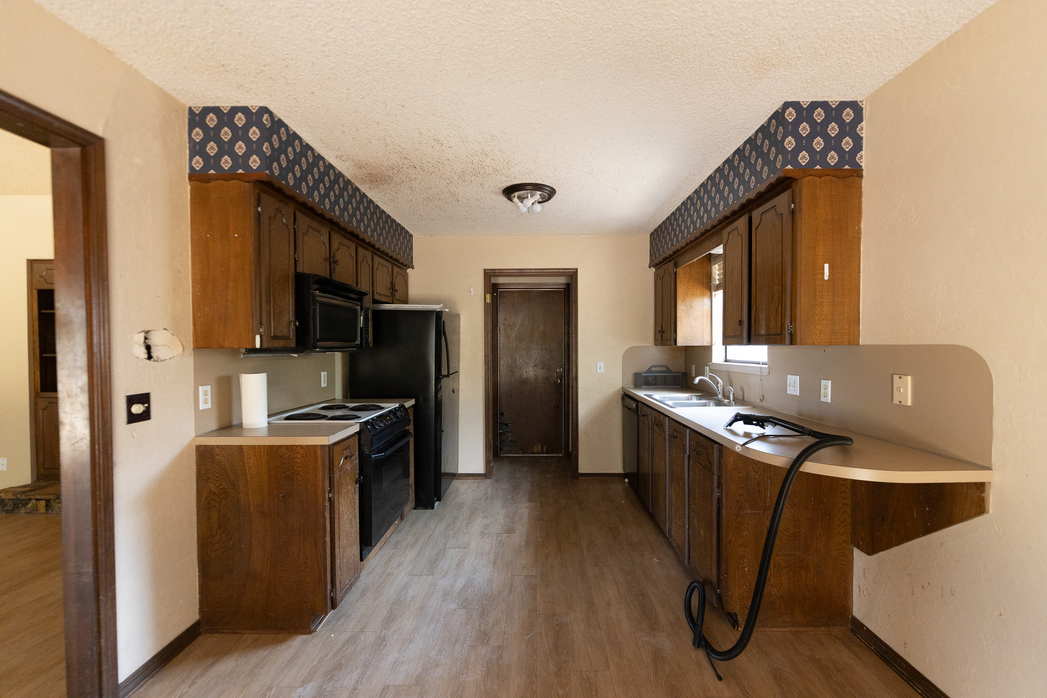 Kitchen before renovation - dark wood cabinets and dated finishes by Renovate Stillwater