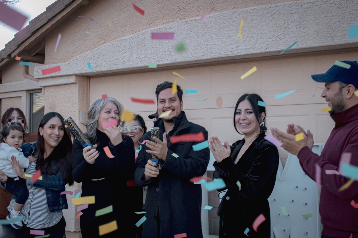 Happy family celebrating in front of their new home in Phoenix, AZ