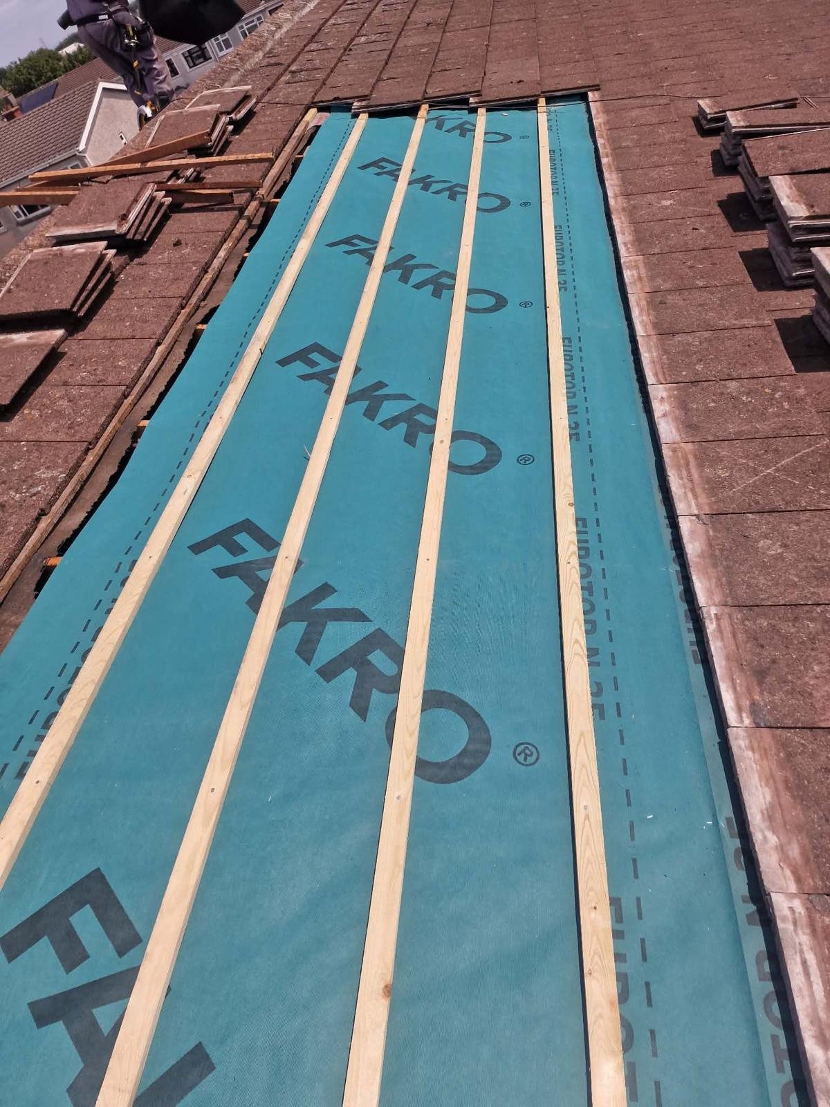 New Fakro breathable roofing membrane and battens laid on a Tallaght roof, with the old tiles stacked ready to re-lay