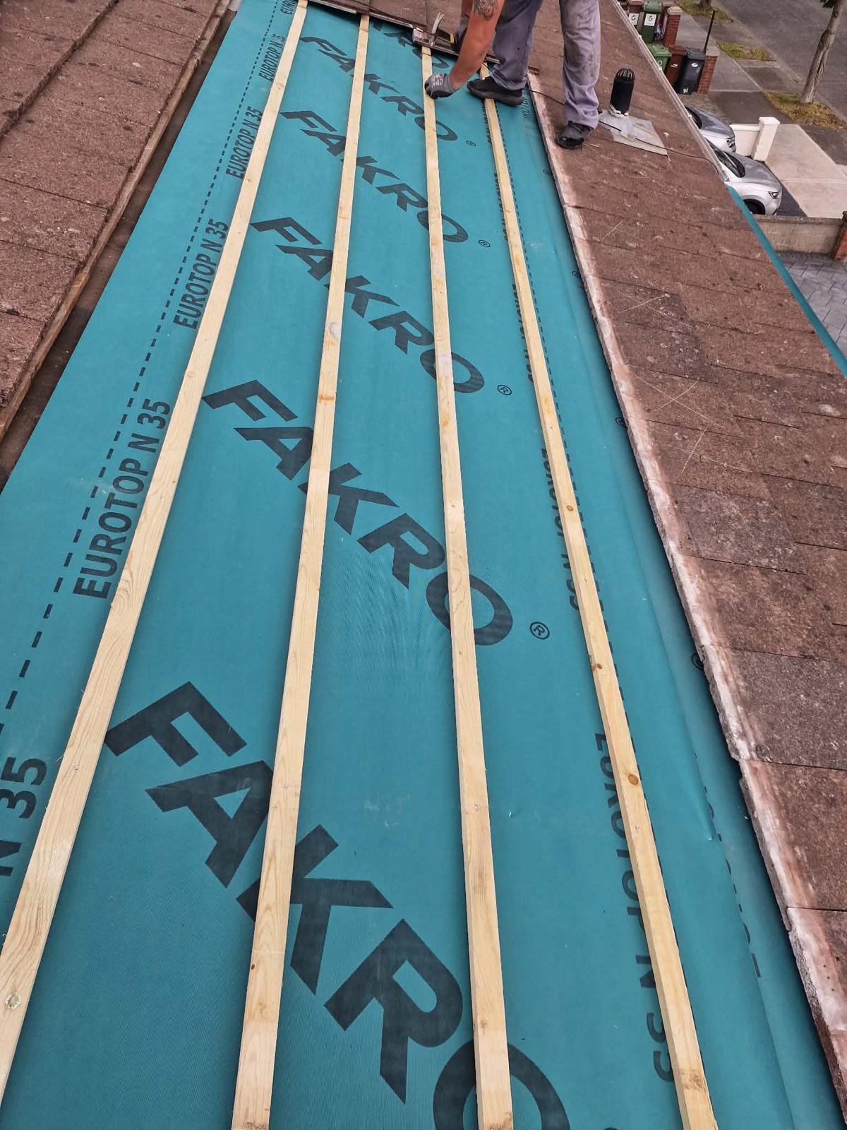 Roofer fixing new timber battens over a Fakro Eurotop N35 breathable membrane on a pitched tiled roof in Tallaght