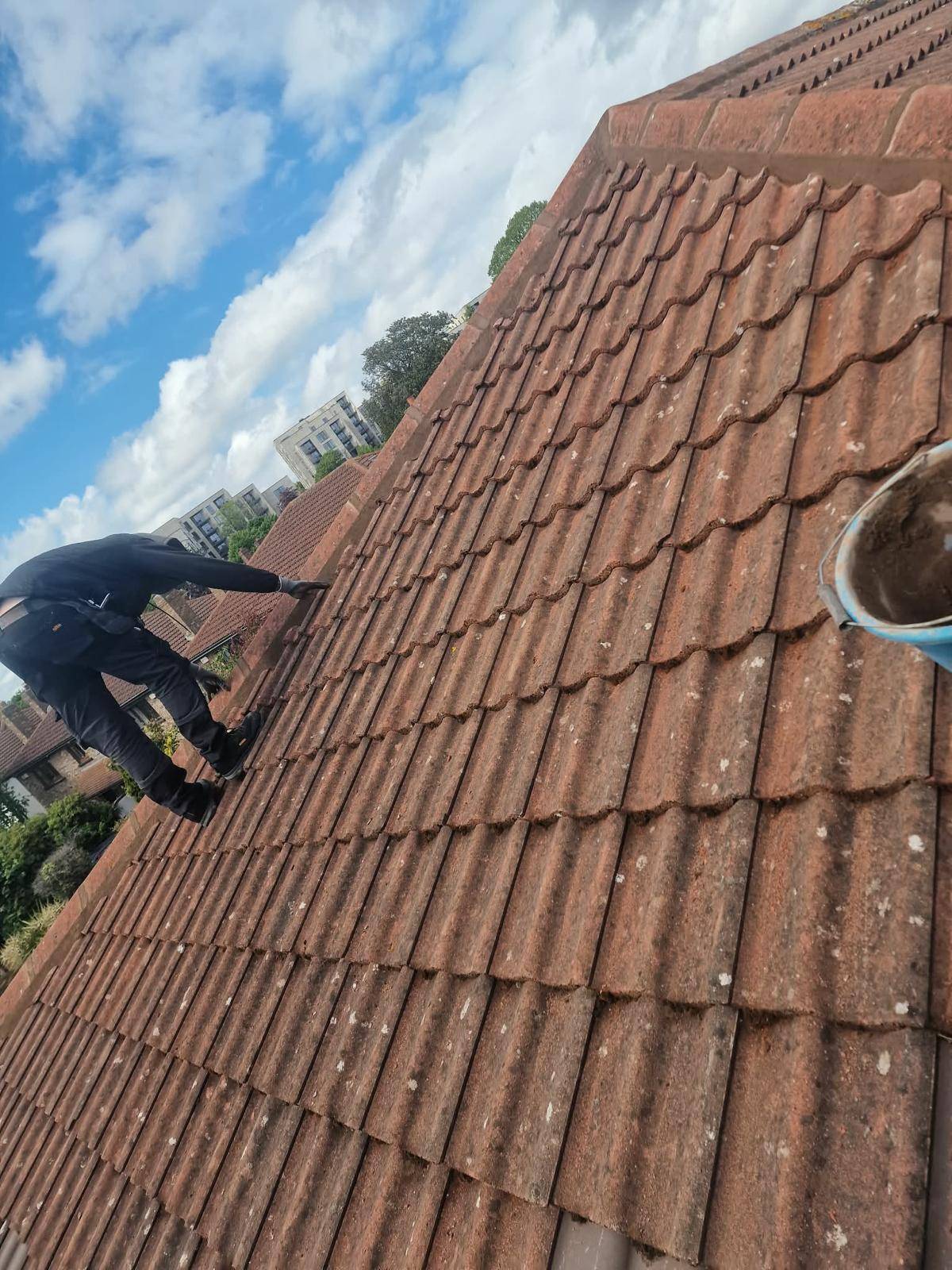 Haven roofer repointing the hip ridge tiles on a red tiled roof in Dundrum, Dublin 16