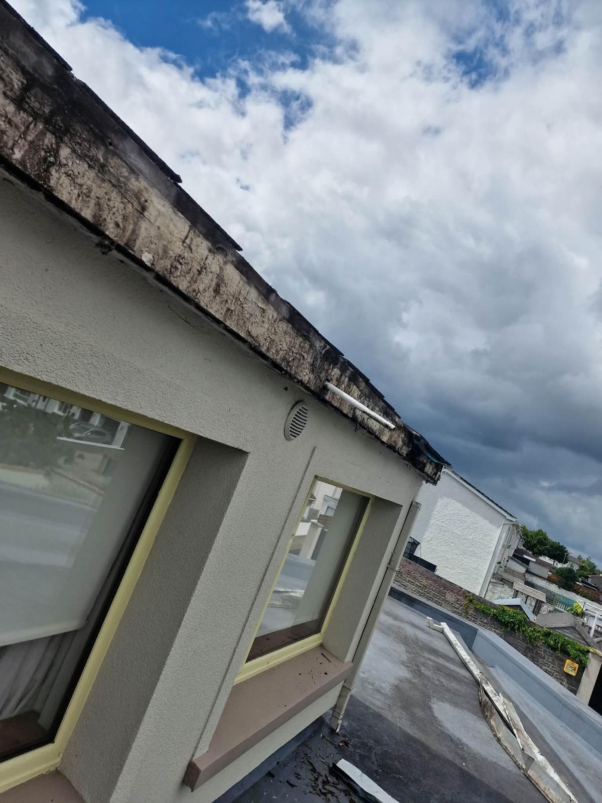 Stained, rotting fascia board along the eaves of a single-storey roof in Tallaght, Dublin 24, before replacement