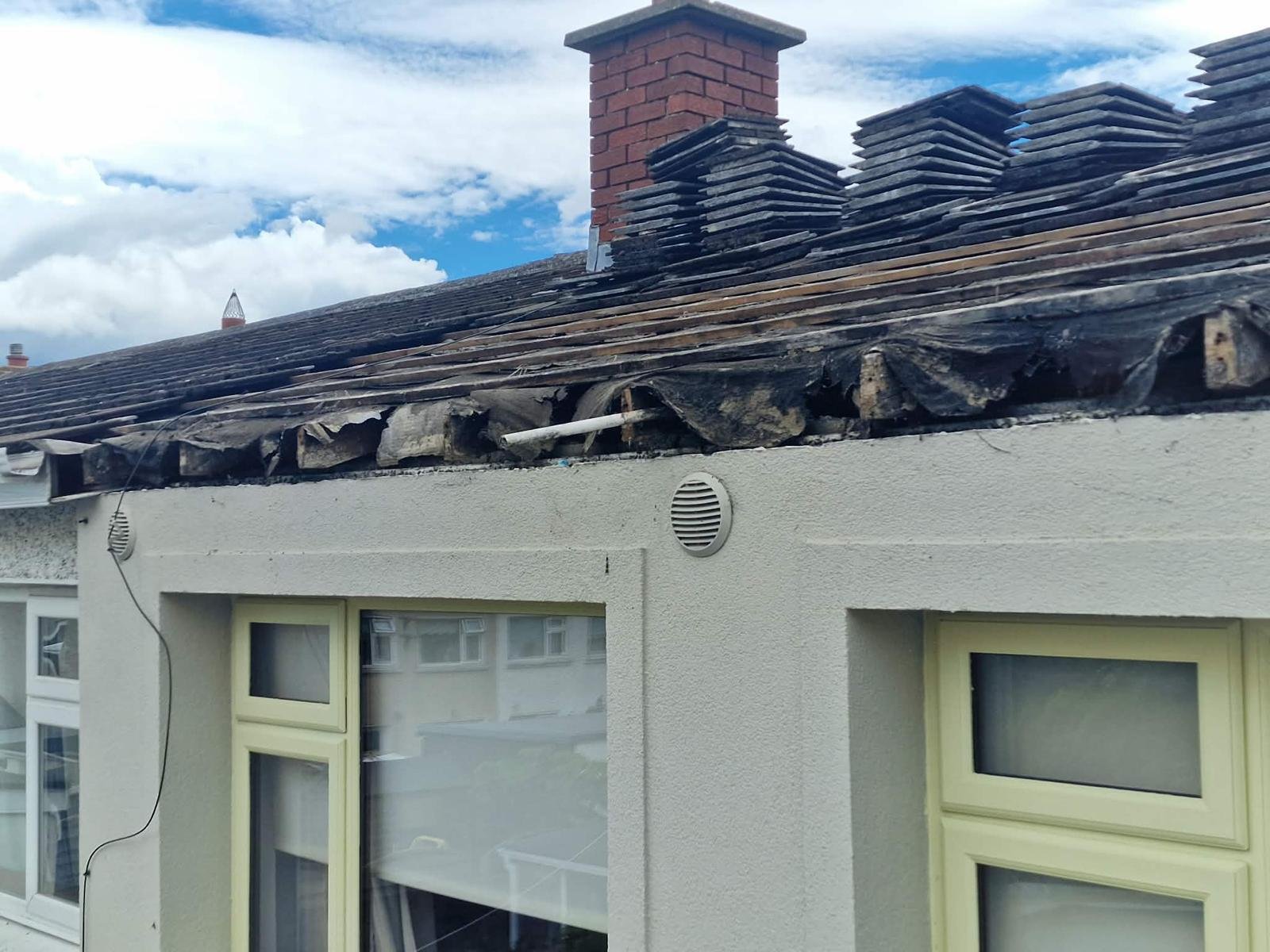Roof tiles lifted and stacked on the ridge, with old torn felt hanging over the eaves, during a Tallaght roof job