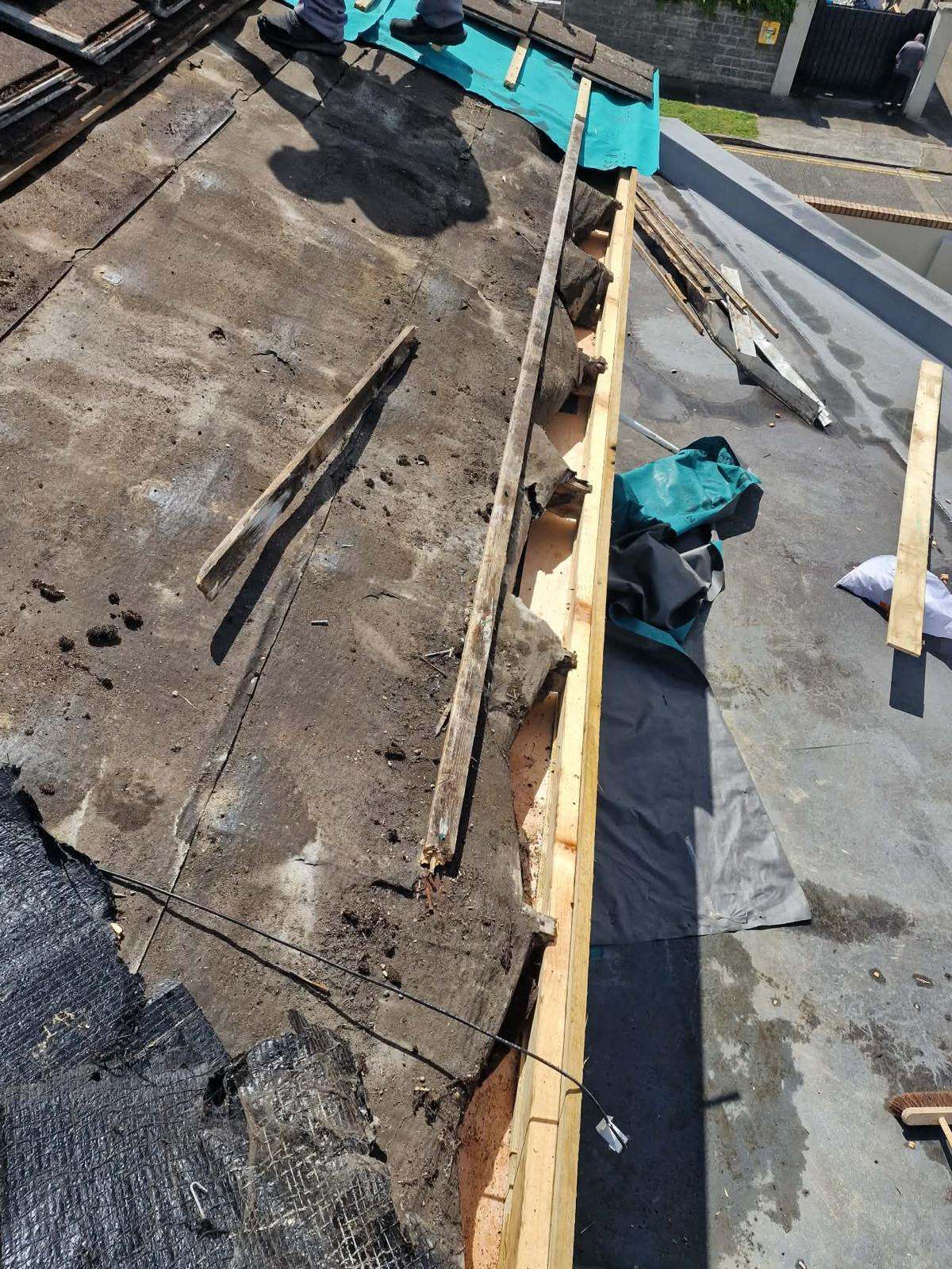 Old perished felt and rotten timber stripped back at the eaves as a new timber fascia board is fitted in Tallaght