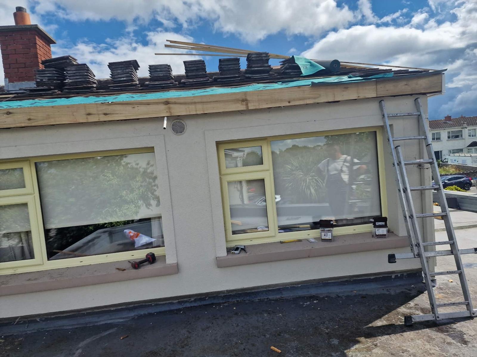 New timber fascia fitted along the front of a single-storey roof in Tallaght, with membrane on and tiles stacked