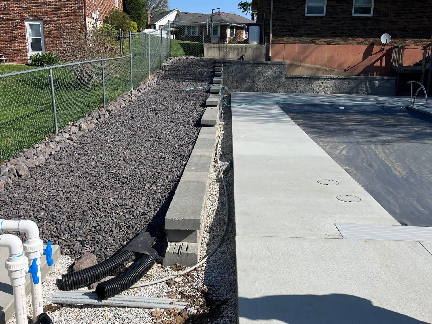 Hardscape steps and retaining wall beside a pool
