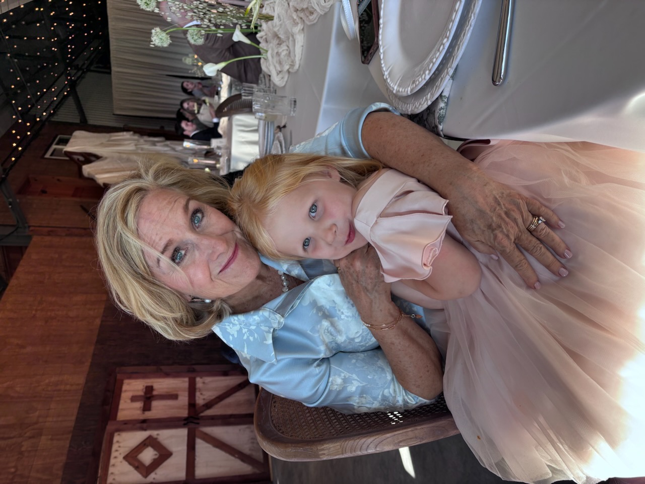 Grandmother holding her granddaughter at an event.