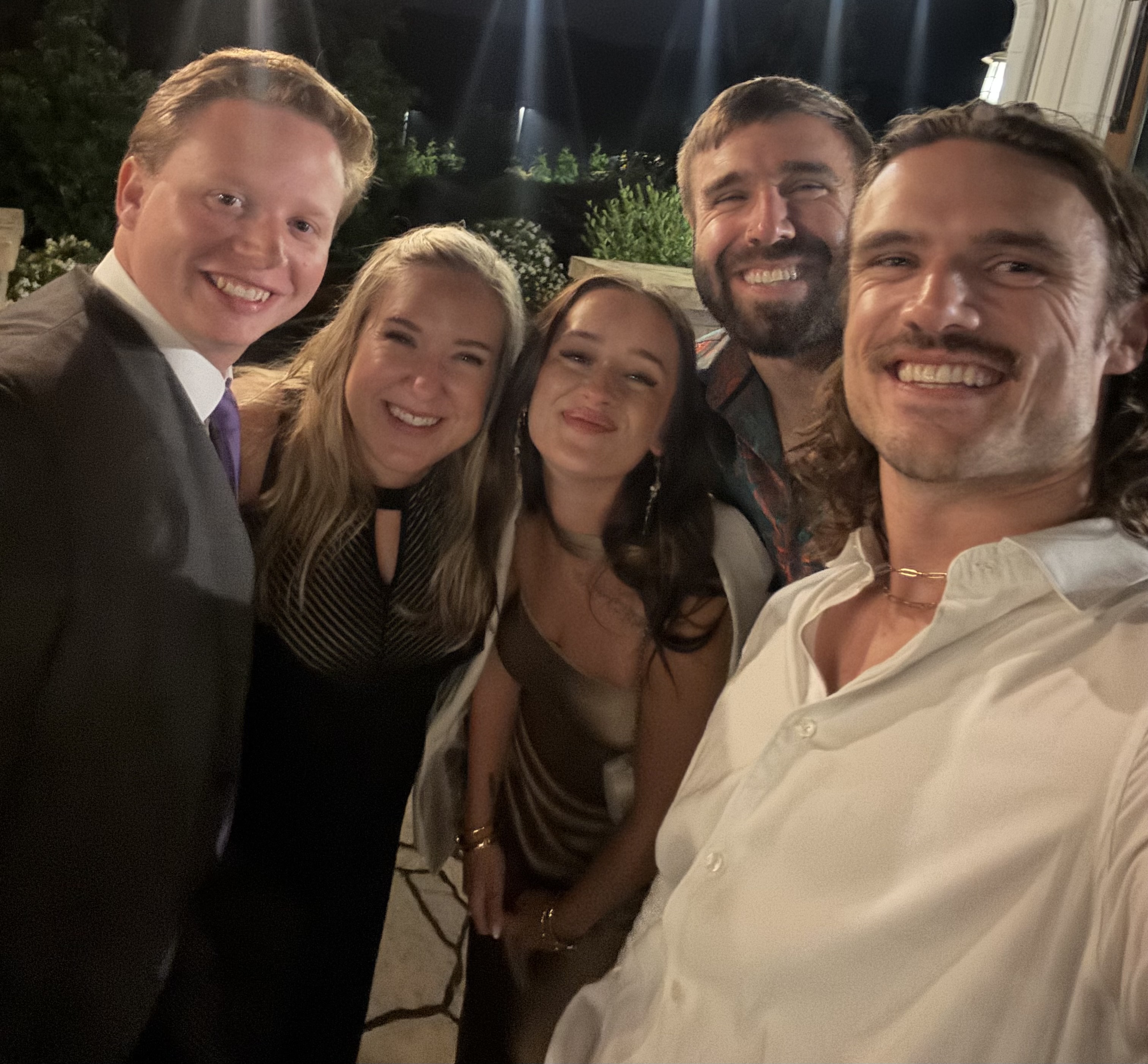 Group of friends or family smiling for a photo at night.