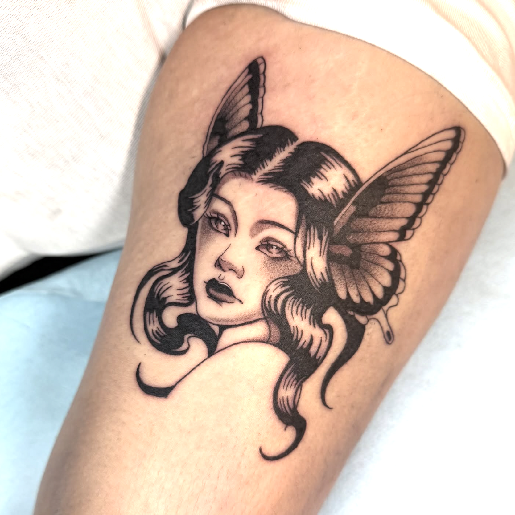 Woman face with butterfly wings tattoo