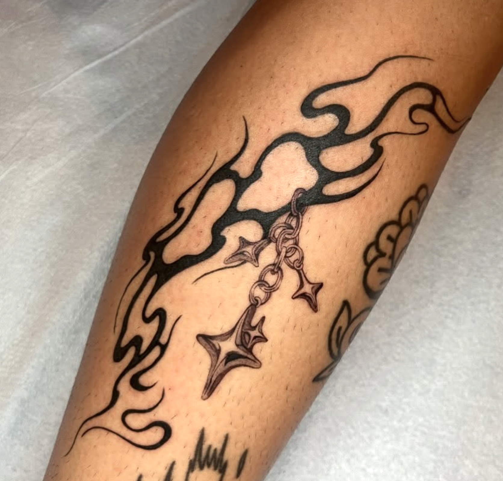 Tribal blackwork tattoo with star chains