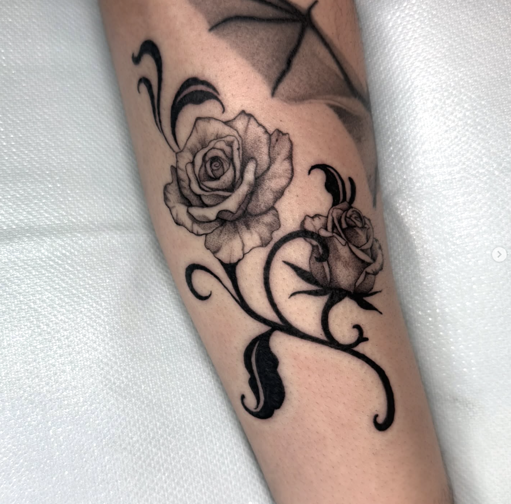 Blackwork rose tattoo with tribal stems