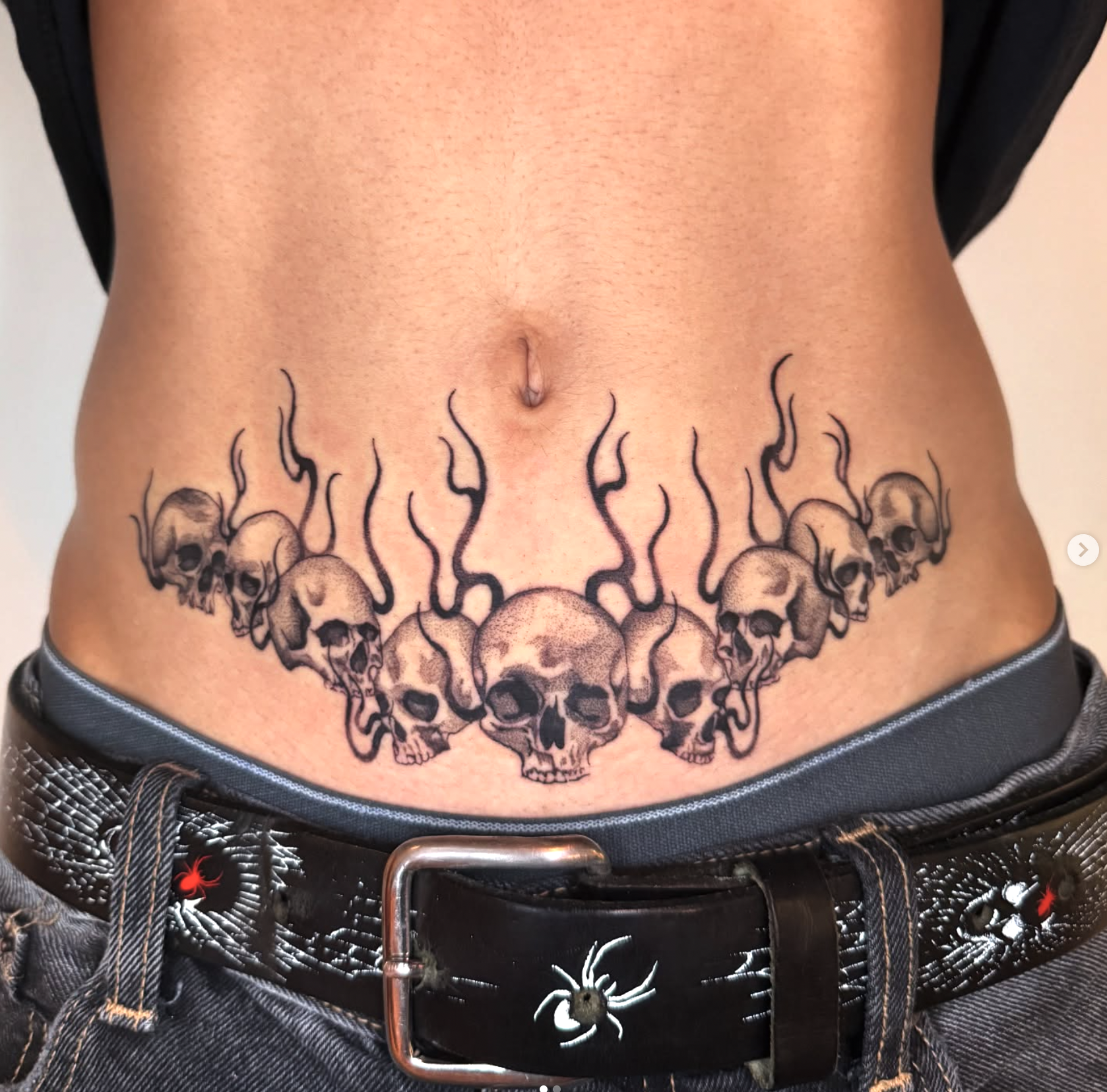 Skull and flames stomach tattoo