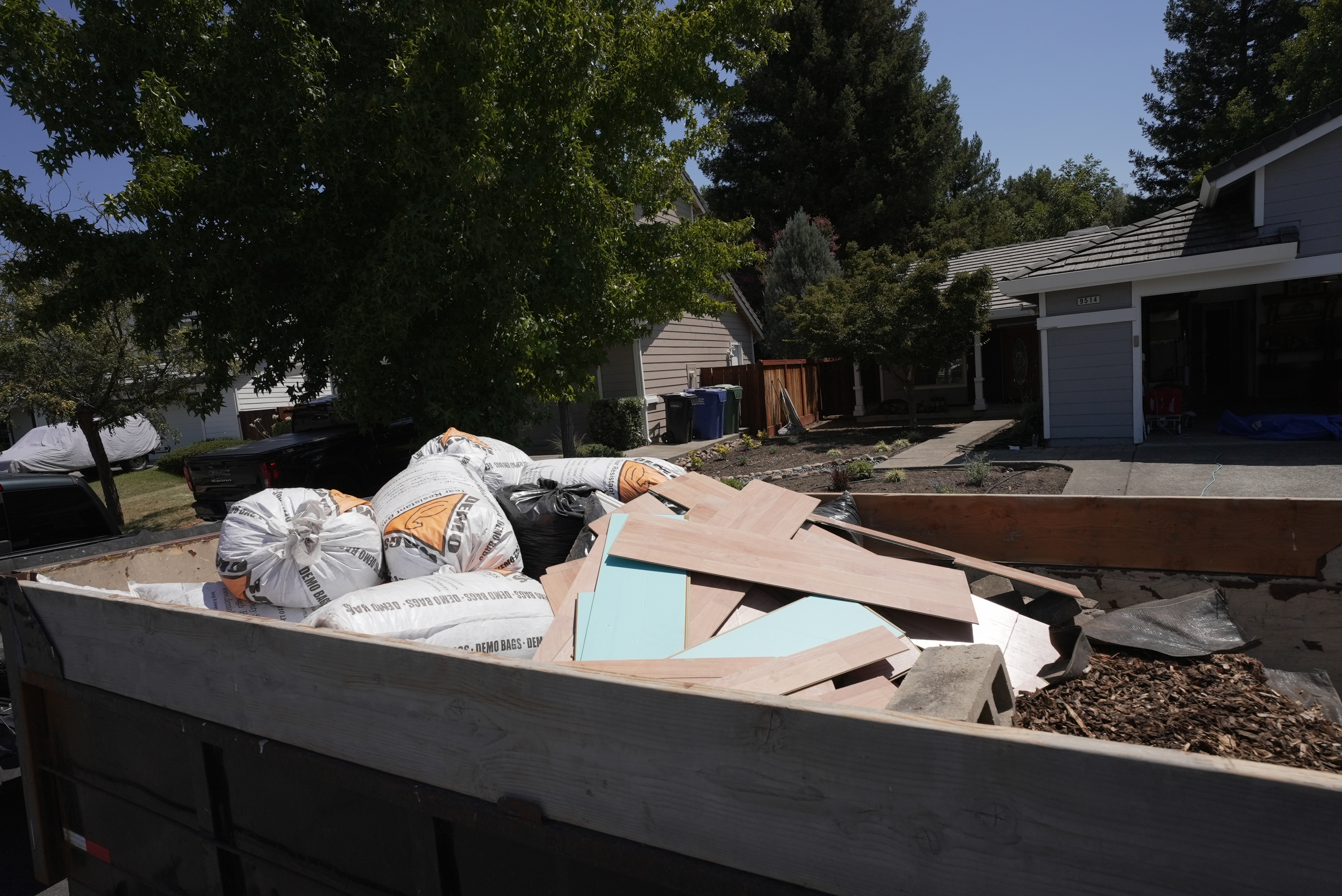 Construction debris removal with demo bags and flooring materials in Sonoma County residential driveway