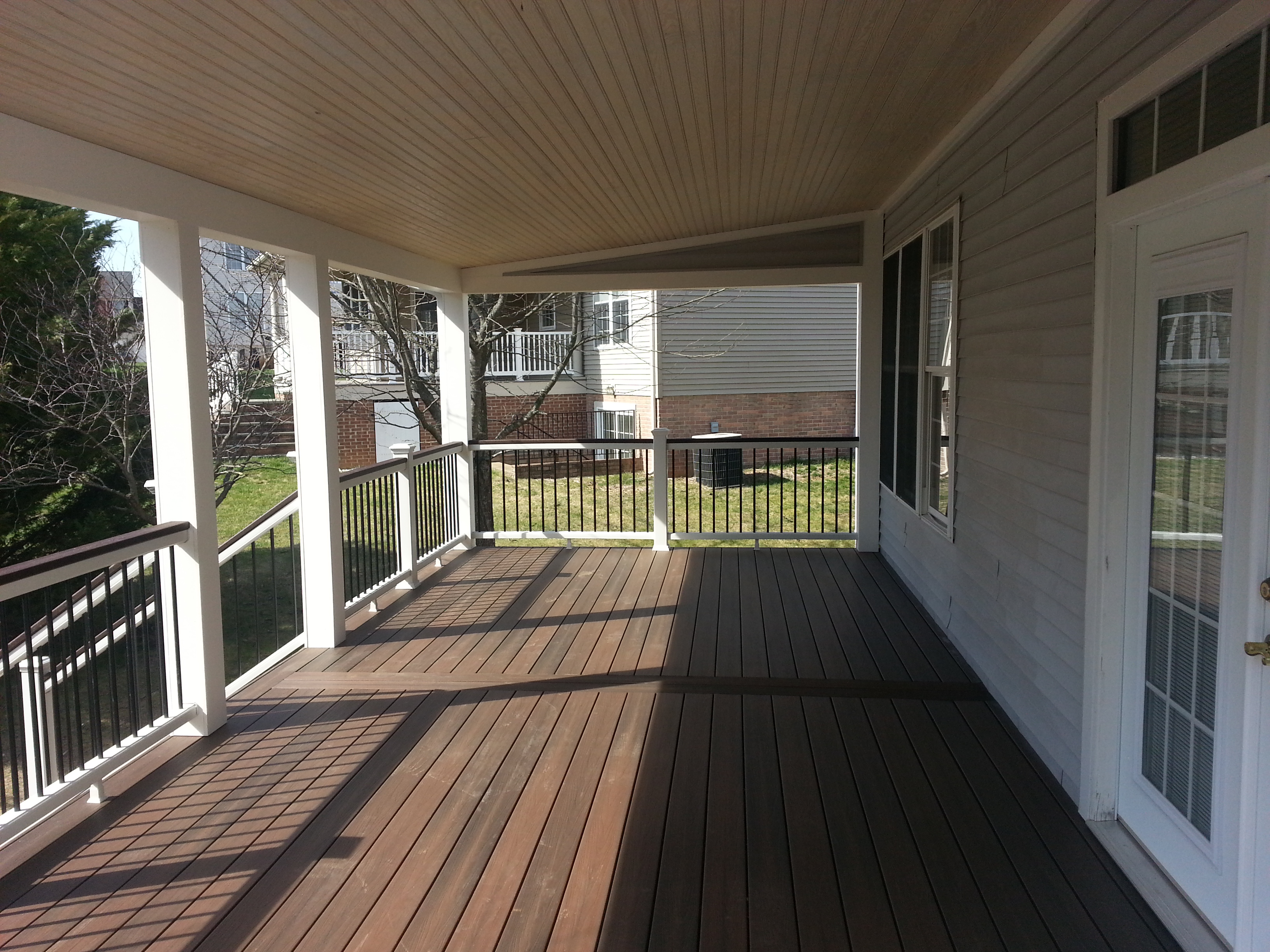 Covered porch with composite decking and black balusters