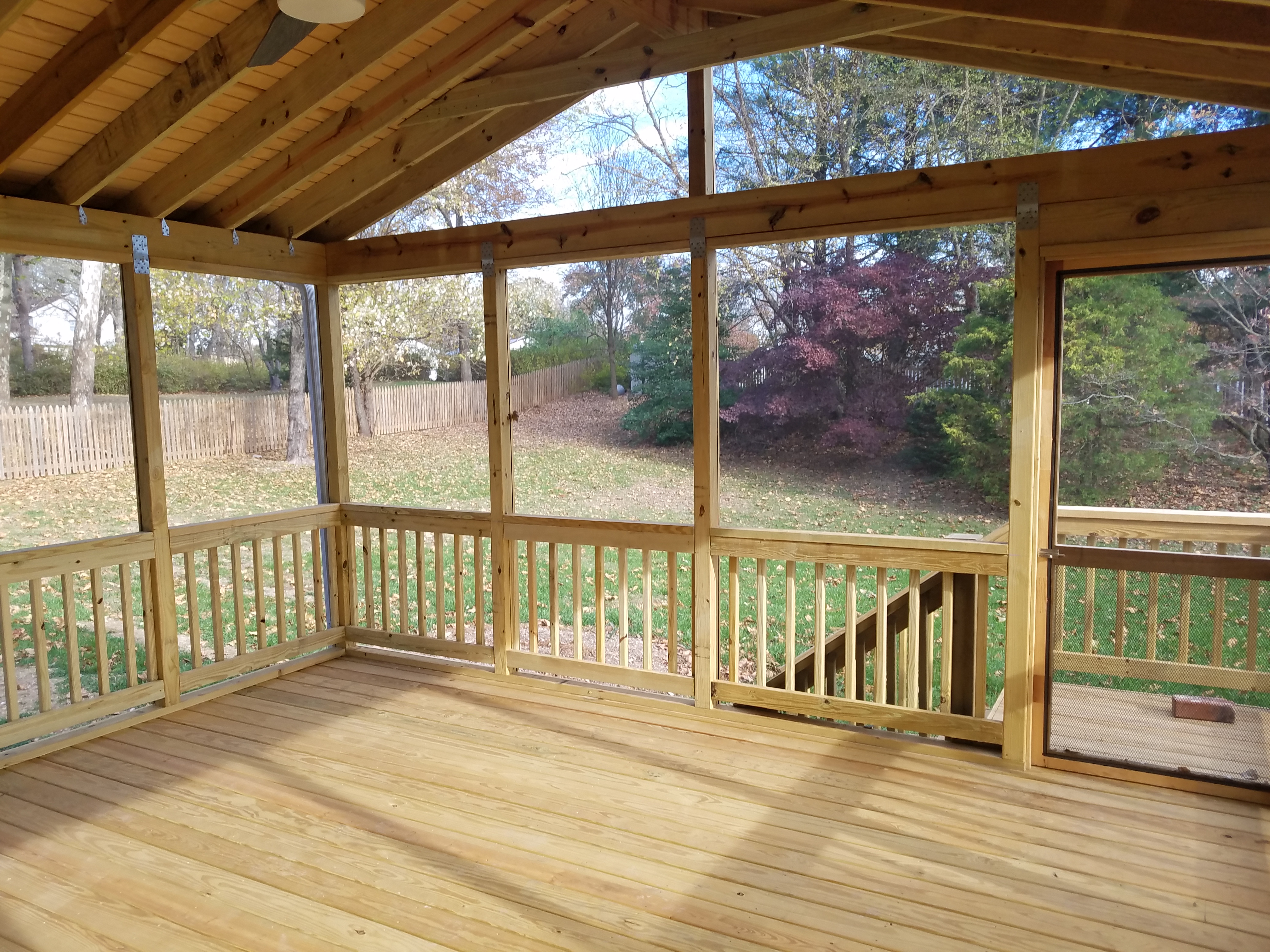 Rustic wood framed screened porch interior